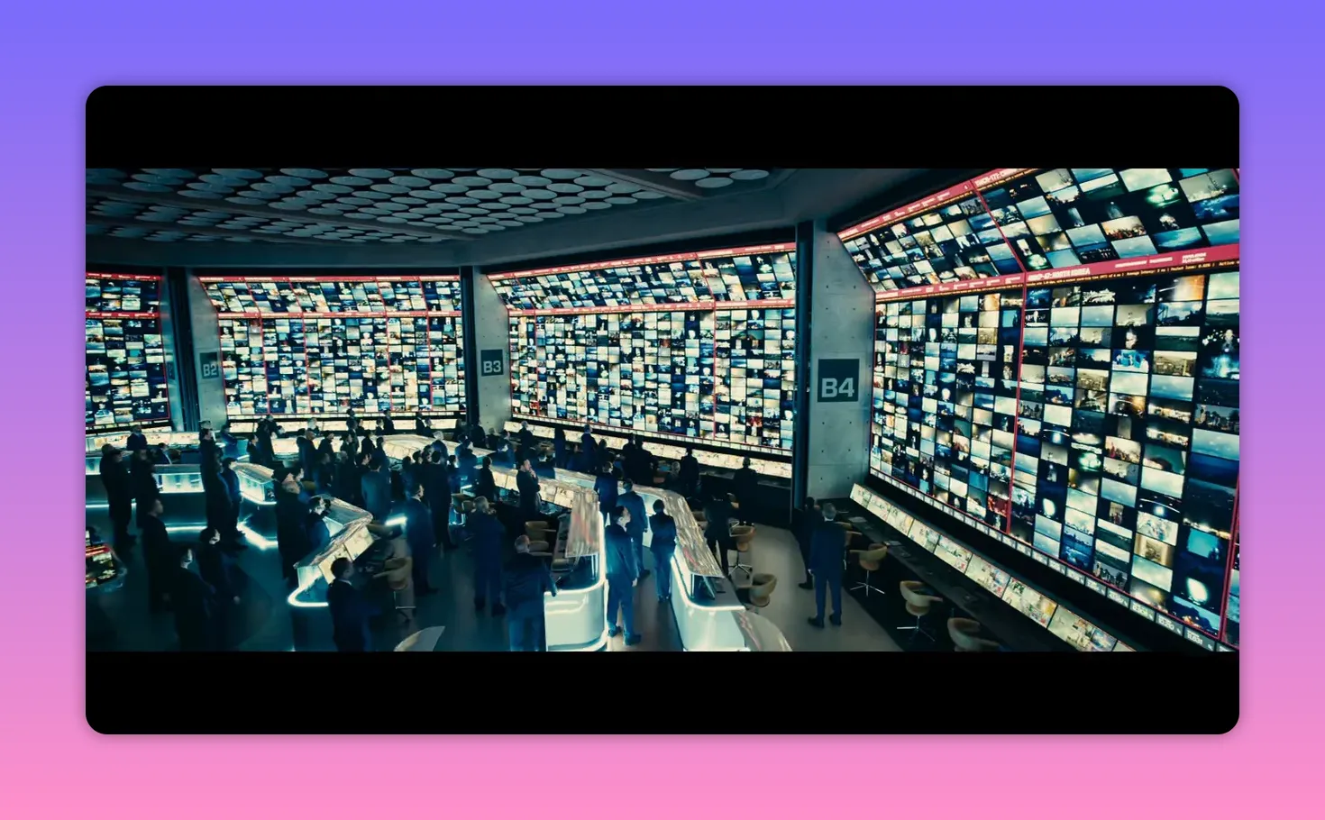 large control room with walls of monitors and analysts working at consoles