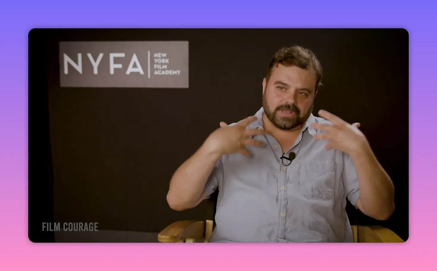Instructor gesturing with hands while explaining directing and teaching exercises in front of a NYFA backdrop