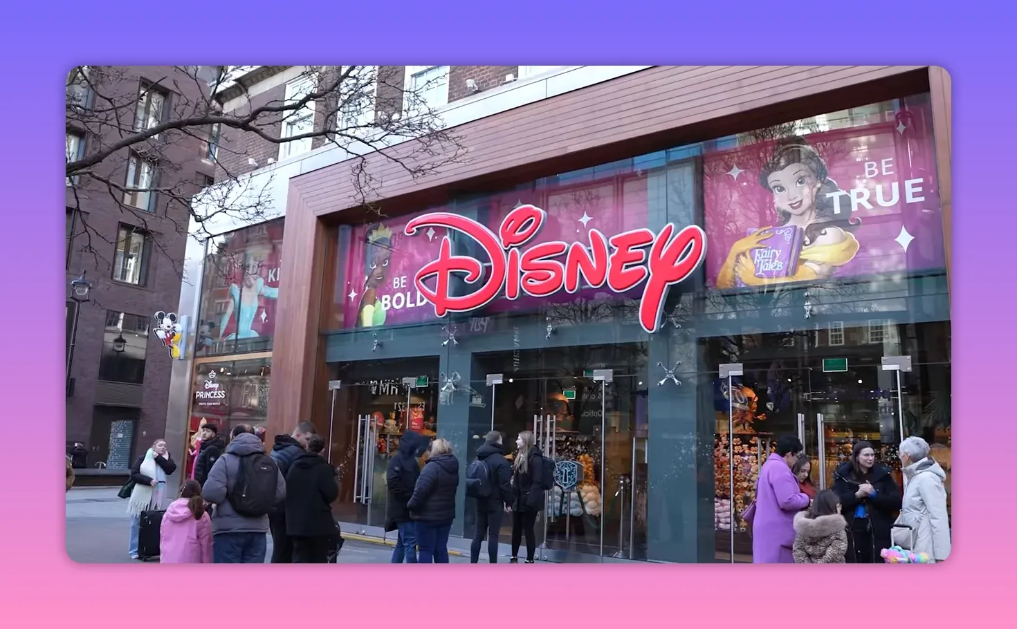 Exterior of a Disney Store with large red Disney sign and people gathered outside