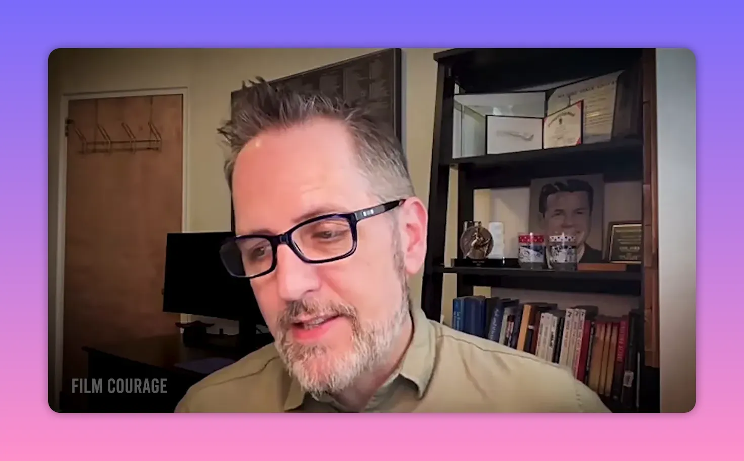 Speaker looking down in a thoughtful pose during a filmed interview in a home office
