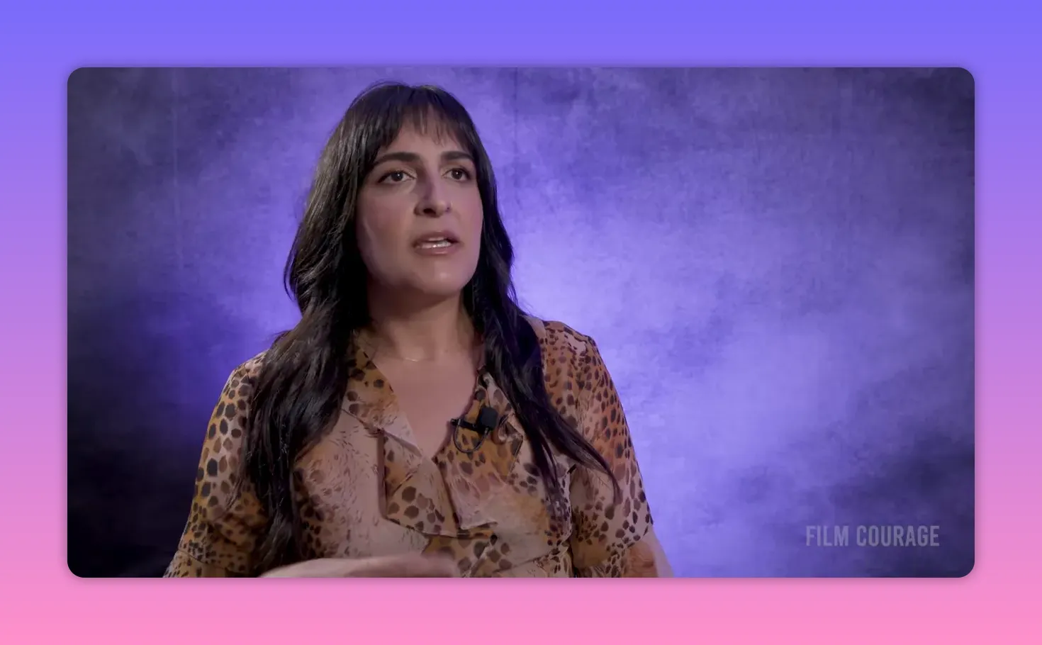 Interview subject explaining coaching techniques with clear focus and a purple textured backdrop.