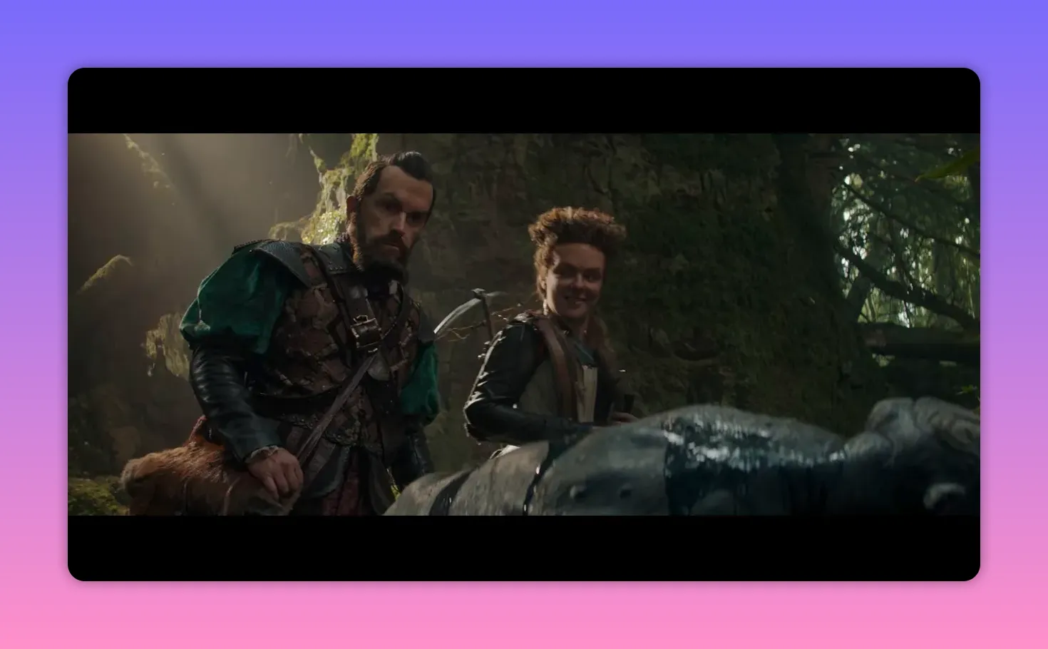 Two characters examining a covered, glistening prop in a mossy forest