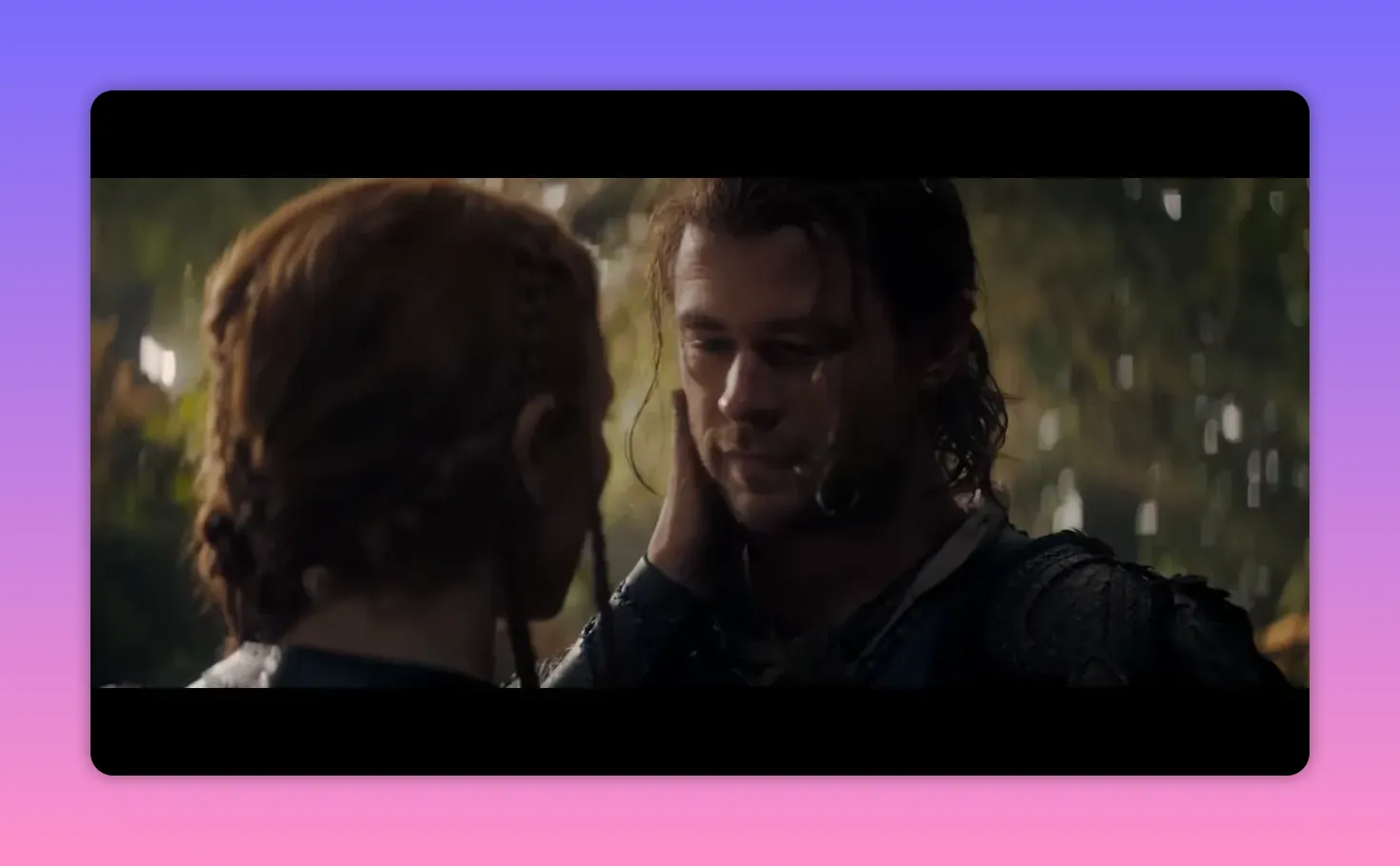 Red‑haired woman touching a man's cheek in an intimate, silent moment in the forest.