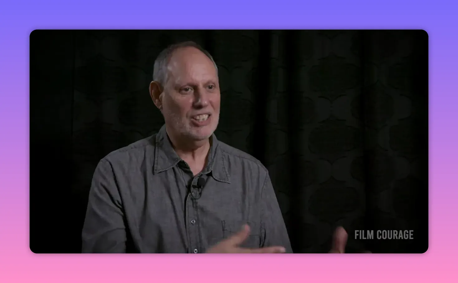 Interview mid-shot of speaker smiling and gesturing with hands while explaining practical exercises