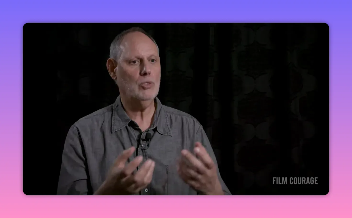 Interview subject making open-hand gestures while describing emotional truth in fiction, clear mid-shot