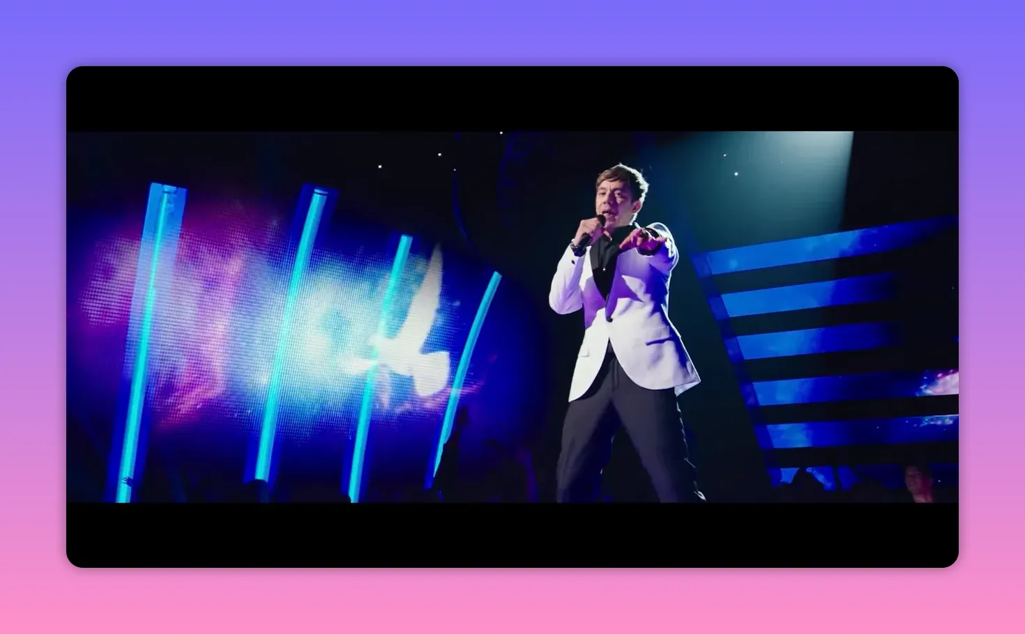 Lead singer in white jacket pointing onstage with a dove projected behind him