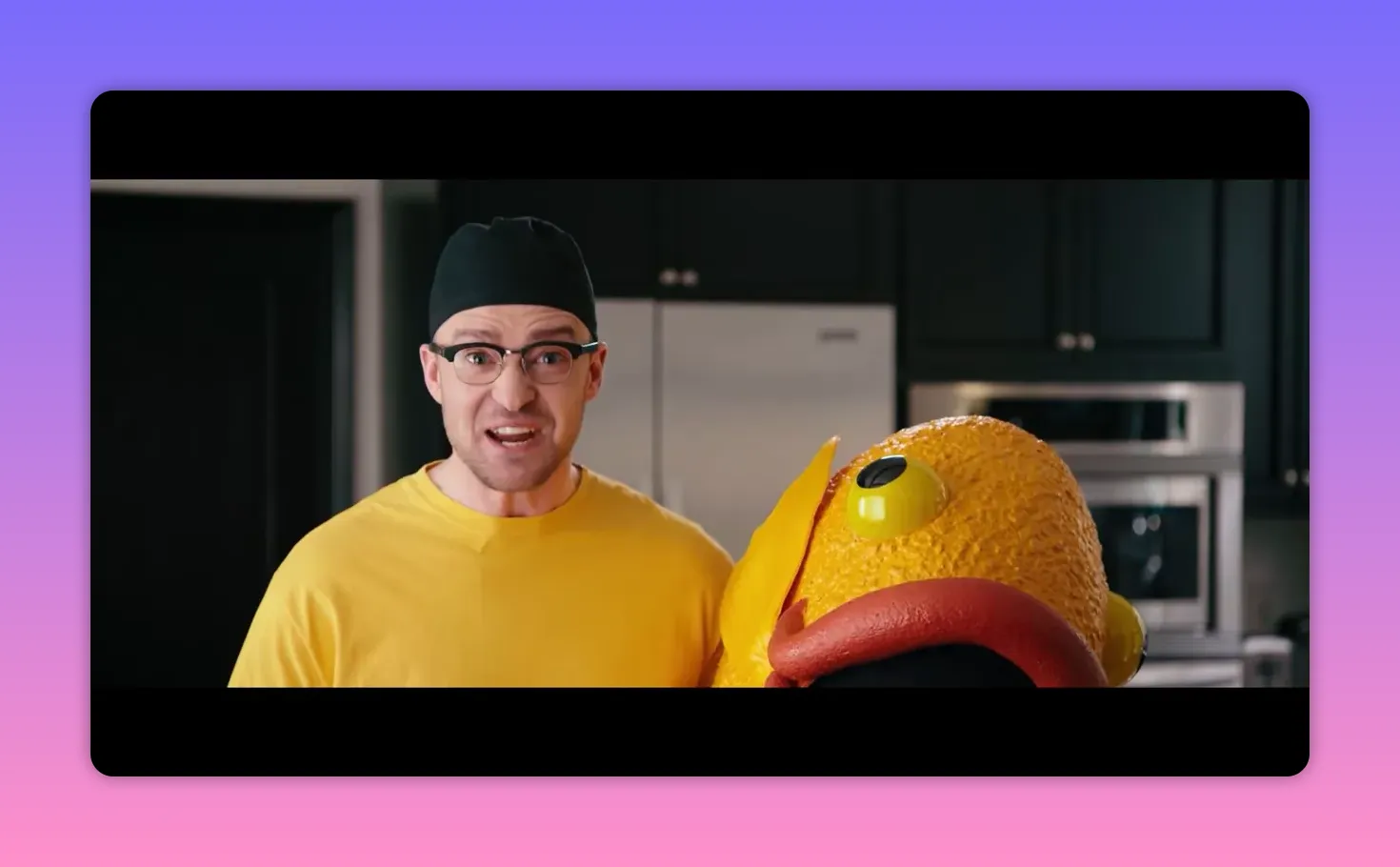 Performer standing next to a large orange fish costume head, revealing who was inside.