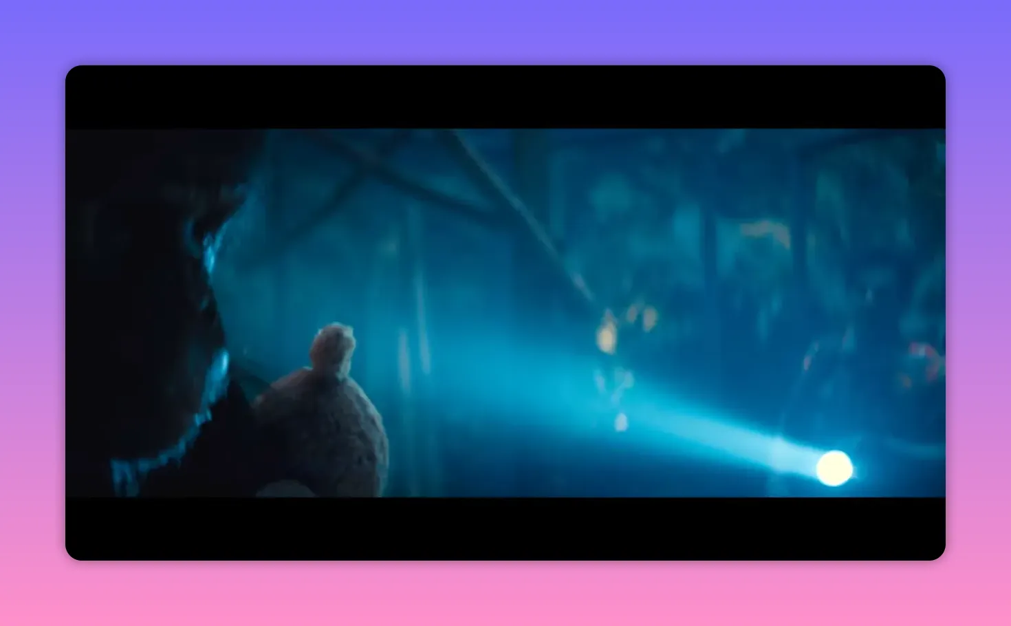 Person holding a teddy bear with a flashlight beam in the dark