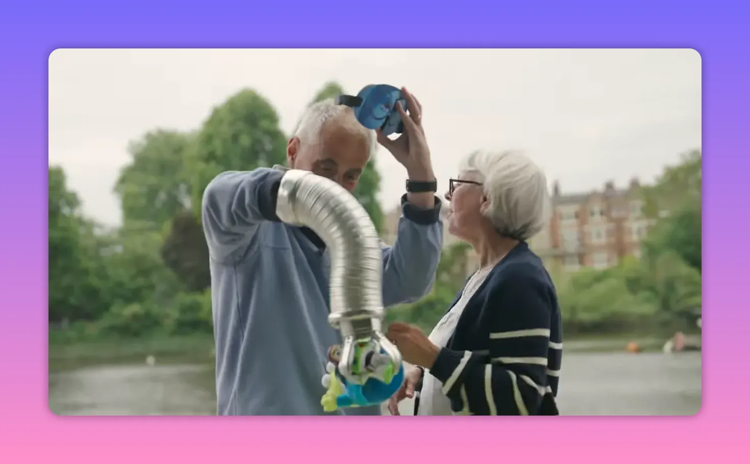 Player lifting a blue blindfold while the mechanical claw holds a toy; their partner looks on nearby by the water.