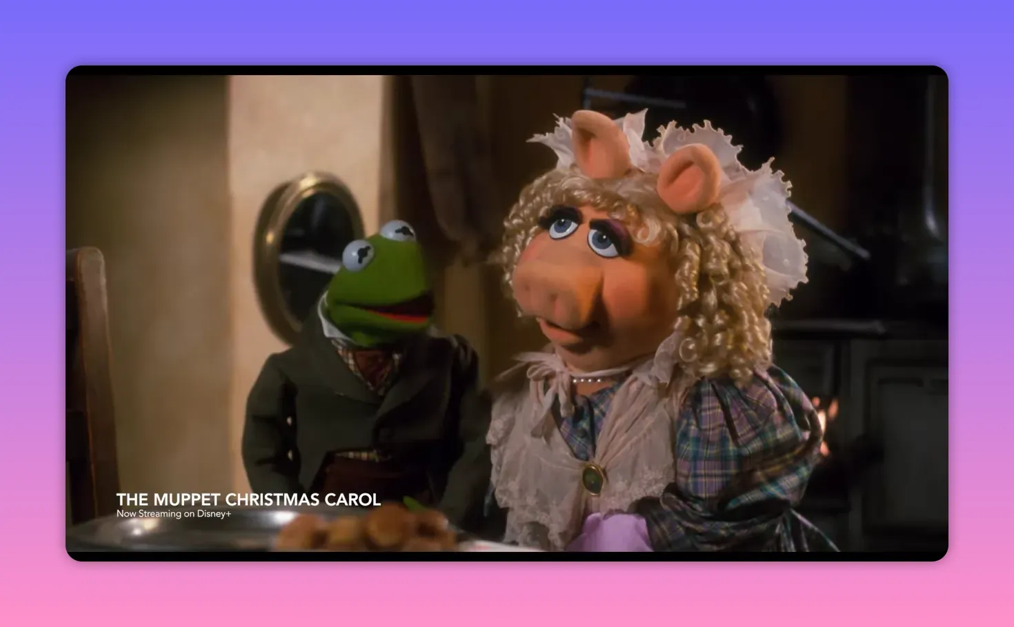 Kermit and Miss Piggy in period costume as Bob and Mrs. Cratchit sharing a warm family moment at the table.