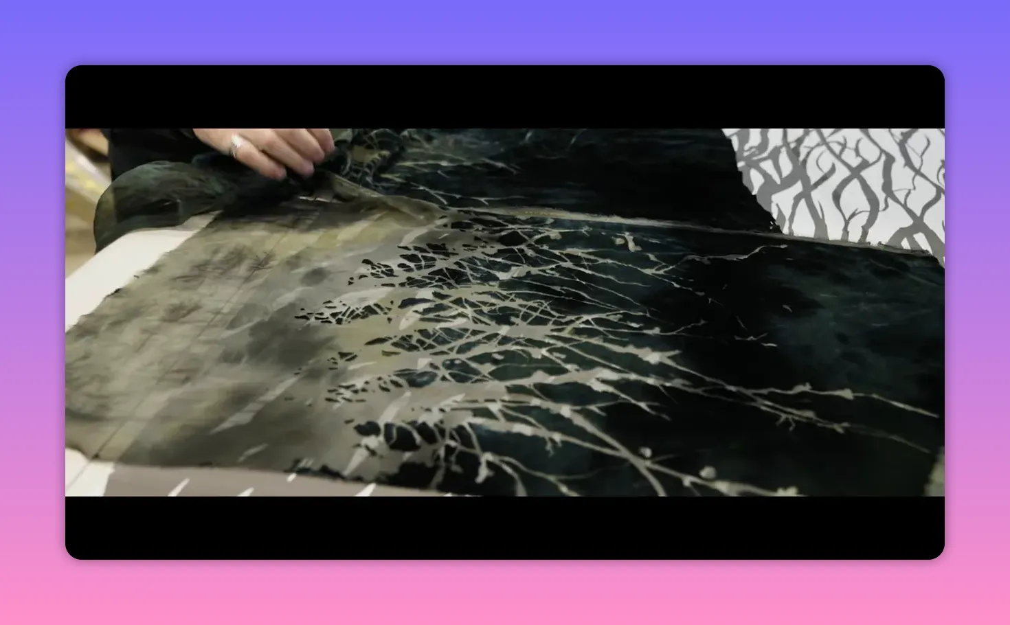 Layered fabric being examined by hand showing printed outer surface and an inner layer