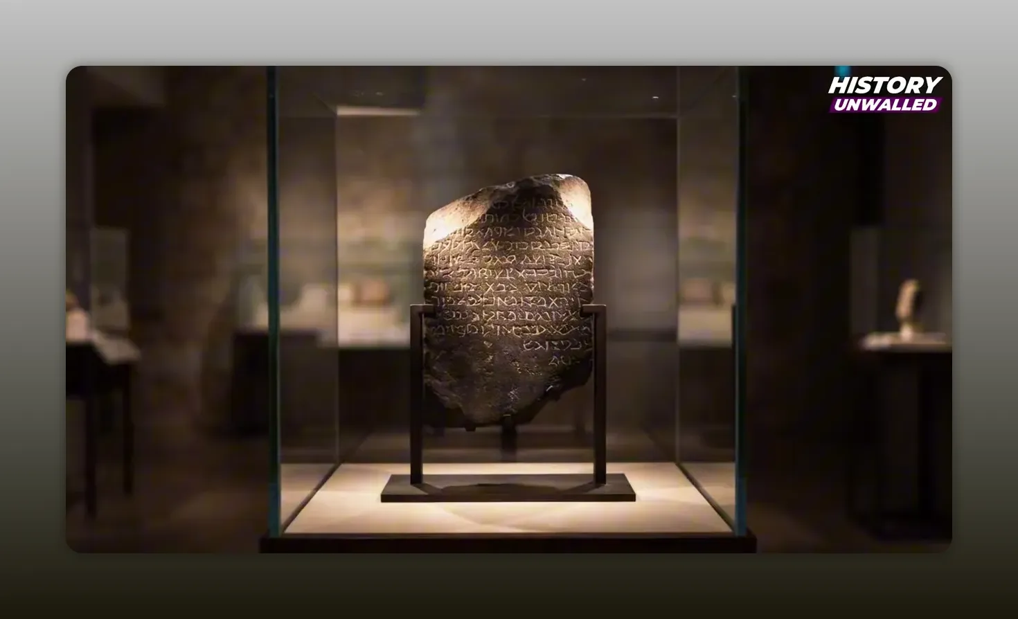 Fragmentary dark stone inscription displayed in a museum case