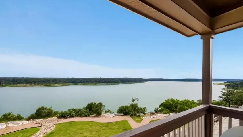 Blue upstairs room with large windows and balcony view toward the lake