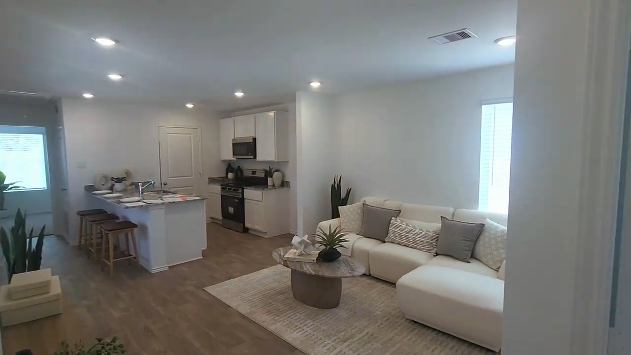 Open living room and kitchen with an on screen two bed two bath floor plan note