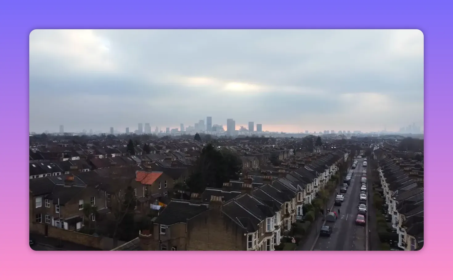 Aerial view of London residential streets and traffic with distant skyline at dusk
