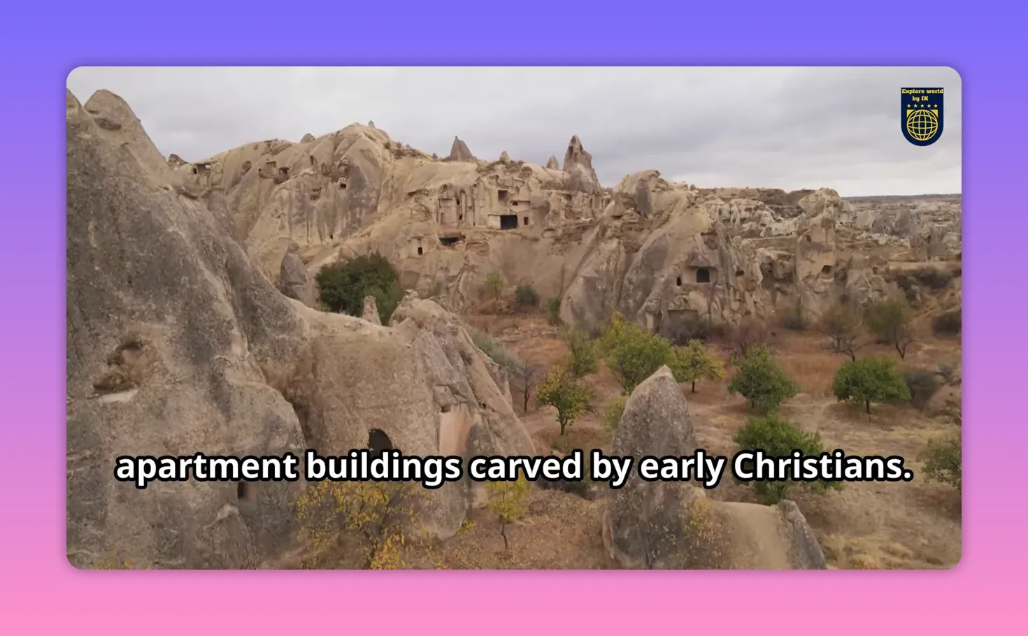 Panoramic view of Cappadocia fairy chimneys and rock‑cut dwellings with trees in the foreground