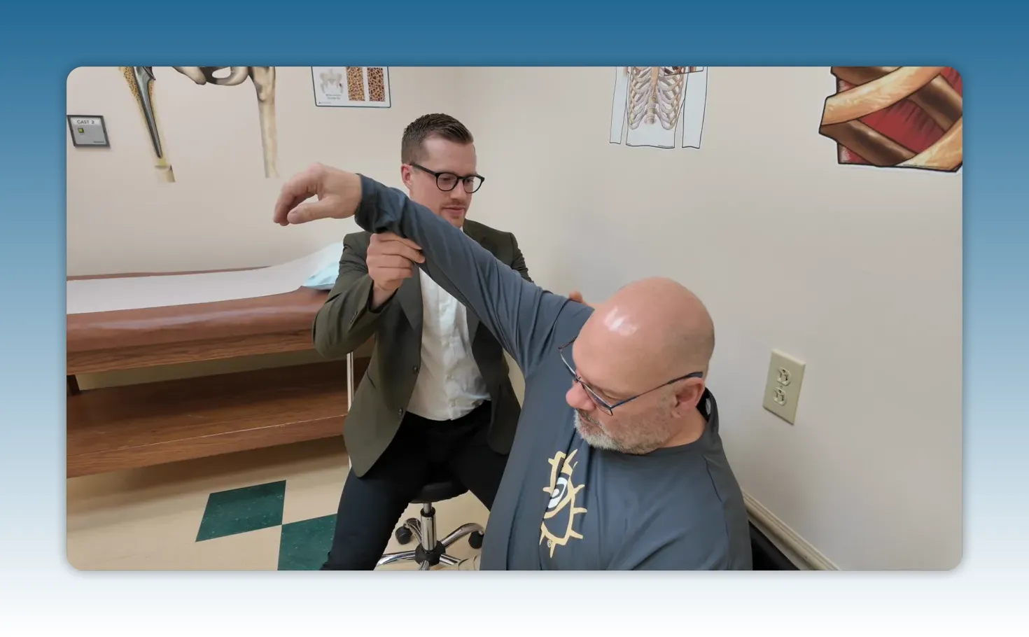 Clinician supporting a patient arm during a shoulder range-of-motion assessment