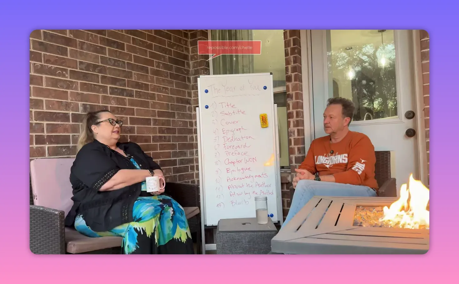 Clear shot of a porch discussion with a central whiteboard titled 'The Year of You' and two seated speakers, minimal glare from the fire pit.