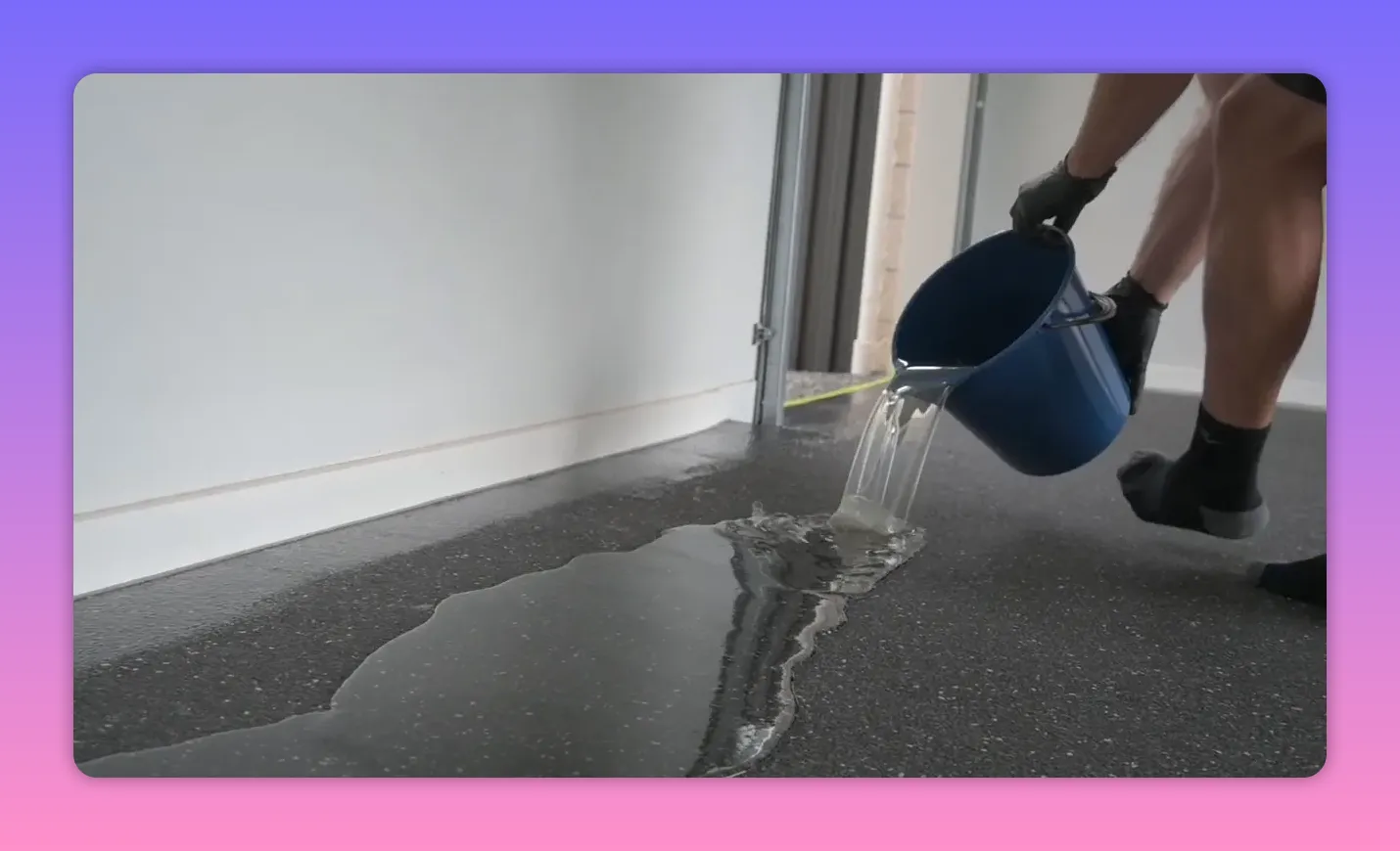 Person pouring water onto a speckled epoxy floor to demonstrate moisture resistance and runoff Person pouring water onto a speckled epoxy floor to demonstrate moisture resistance and runoff