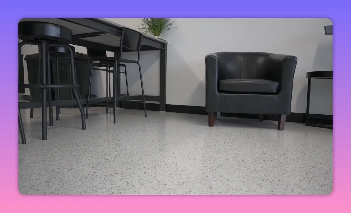 Multi‑flake epoxy floor in a furnished room showing chair and table legs Multi‑flake epoxy floor in a furnished room showing chair and table legs