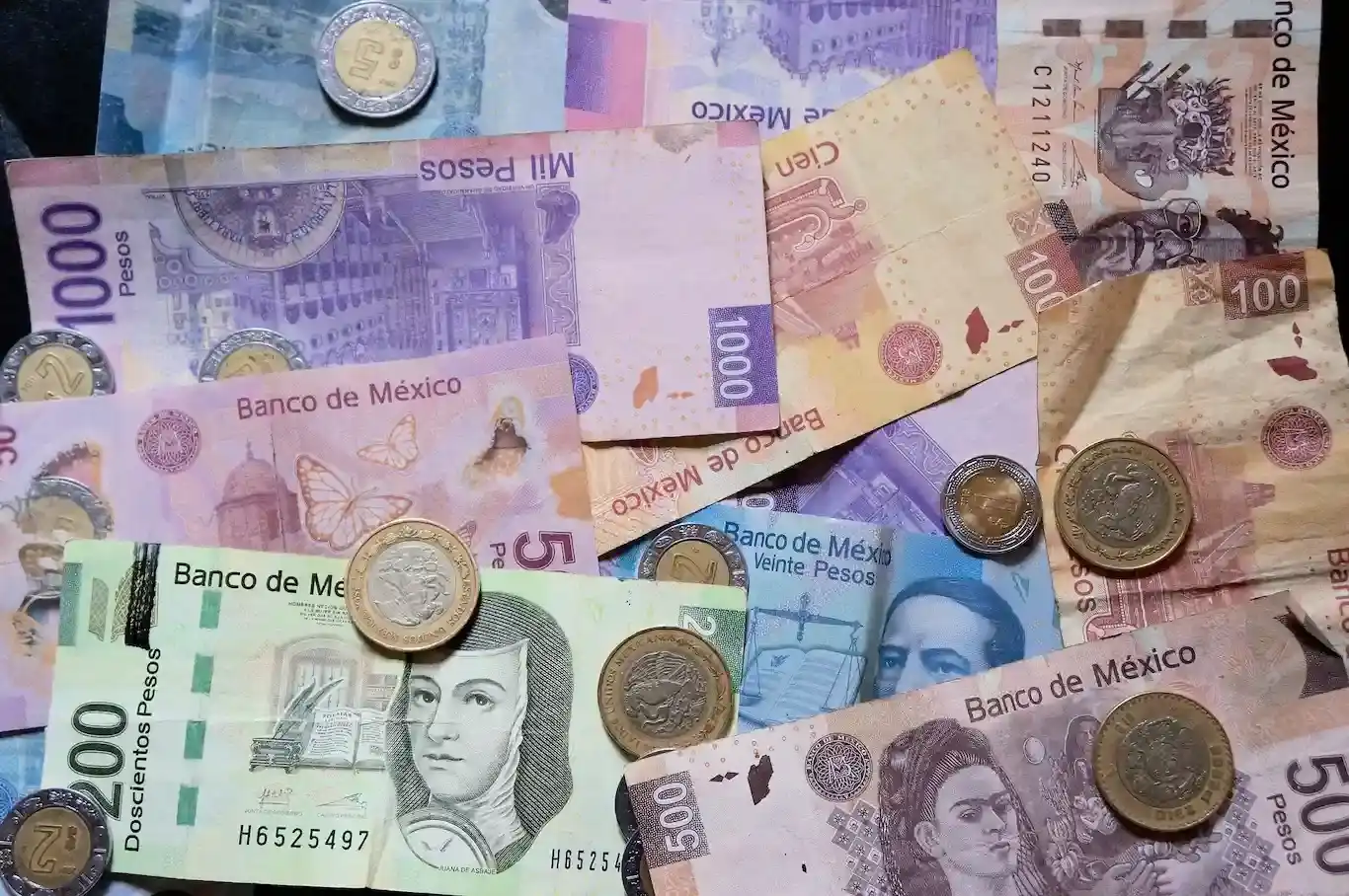 A pile of Mexican pesos, bills and coins.