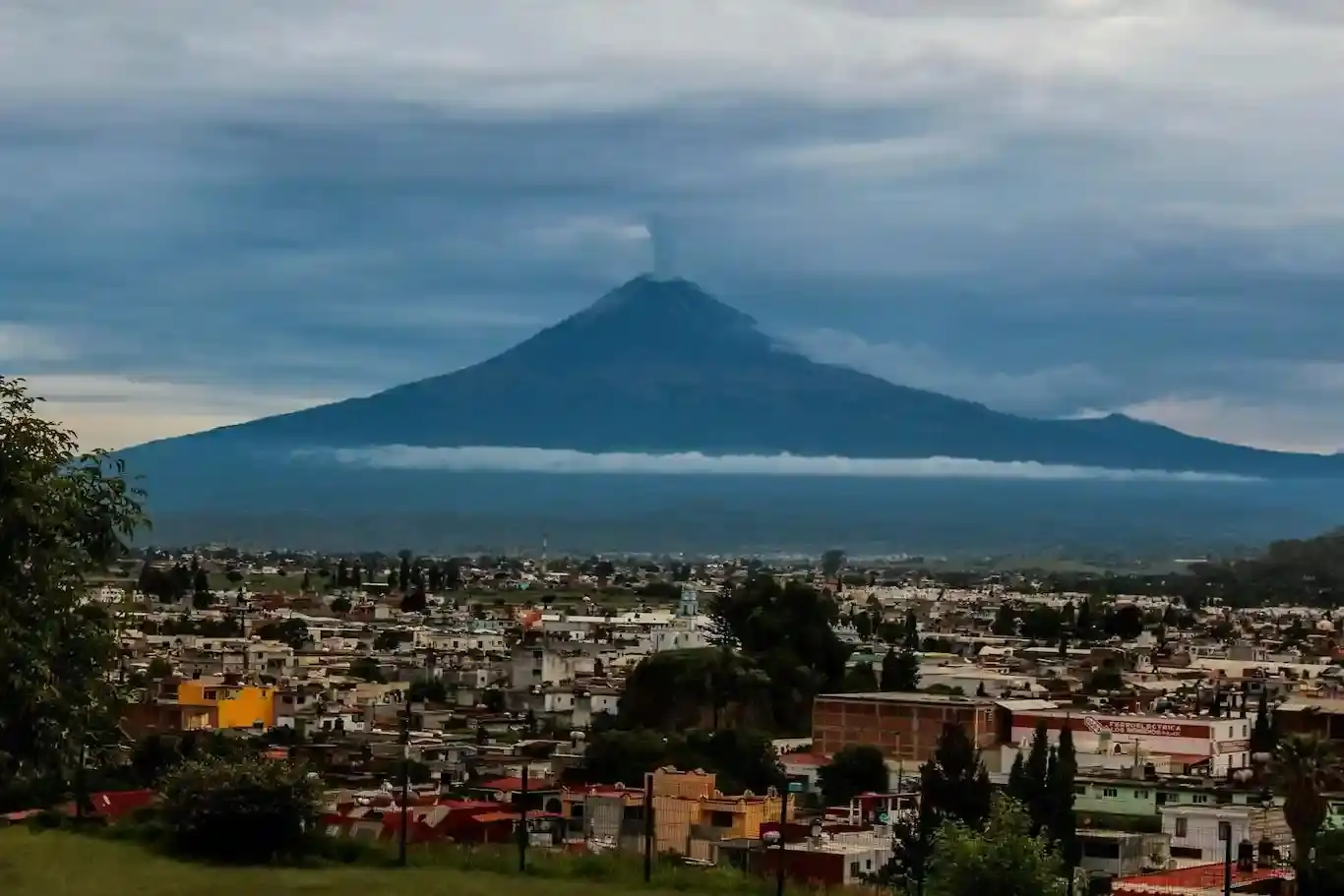 A photo of the Popocatépetl volcano spewing ash behind Mexico City.jpg