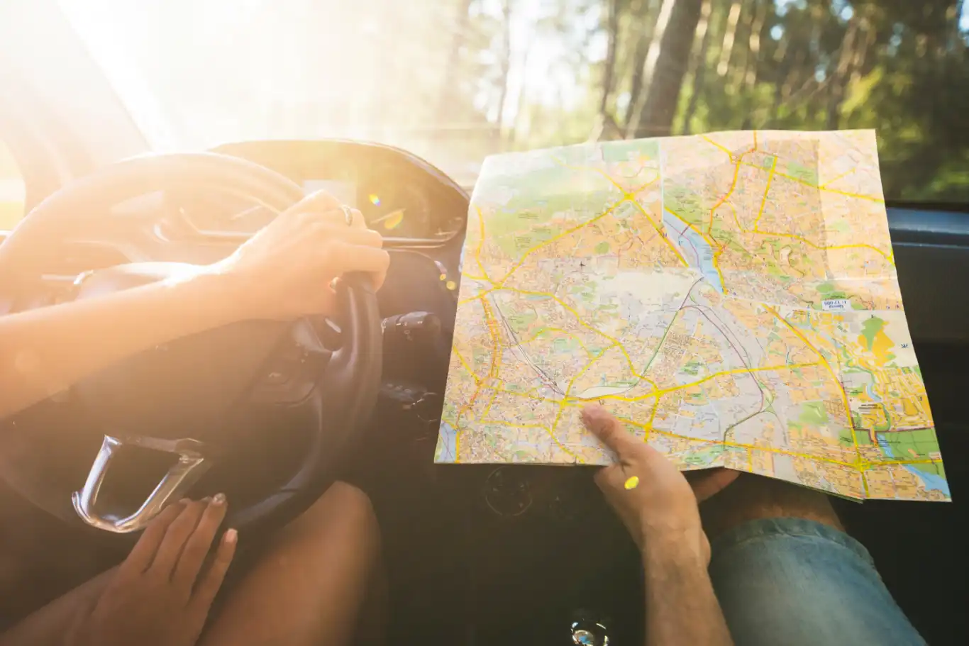 Couple on a car trip looking at map