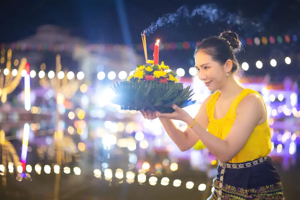 A Thai woman holds a Krathong ornamental form banana leafs in Loy Krathong celebrations in Thailand for the goddess of water on a full moon night