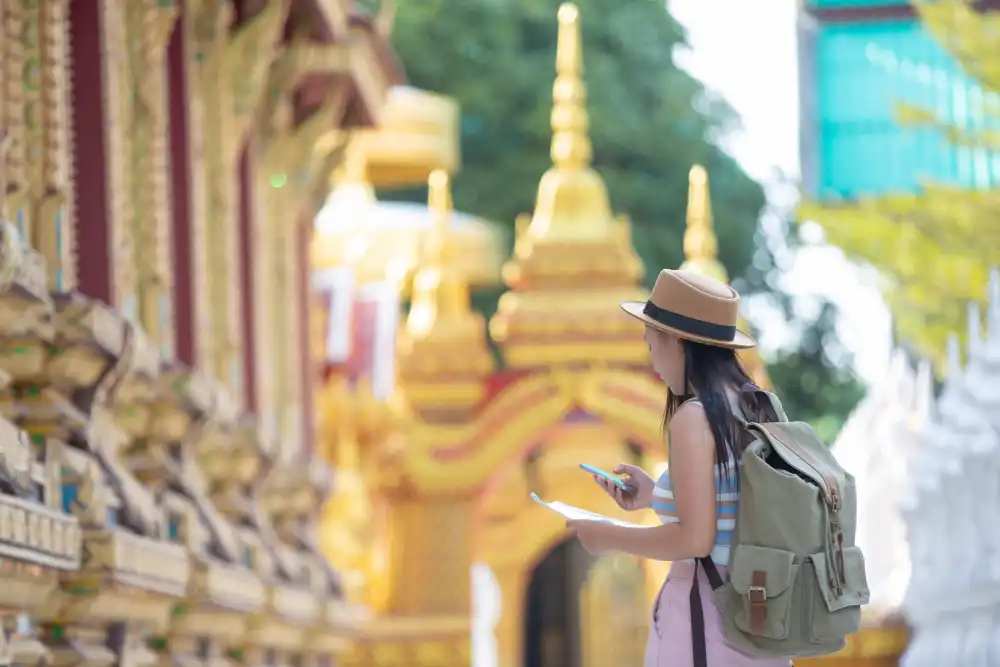 Female tourists hold a map and phone to find places.