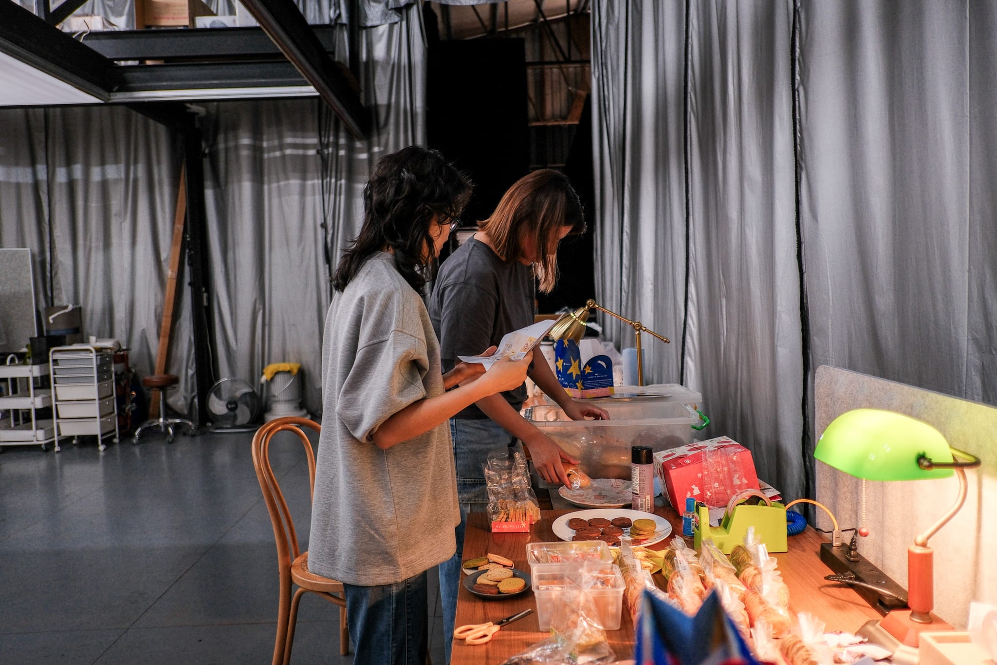 攝影師與行銷專員在擺滿肯納兒餅乾的桌前，專注討論著拍攝細節。