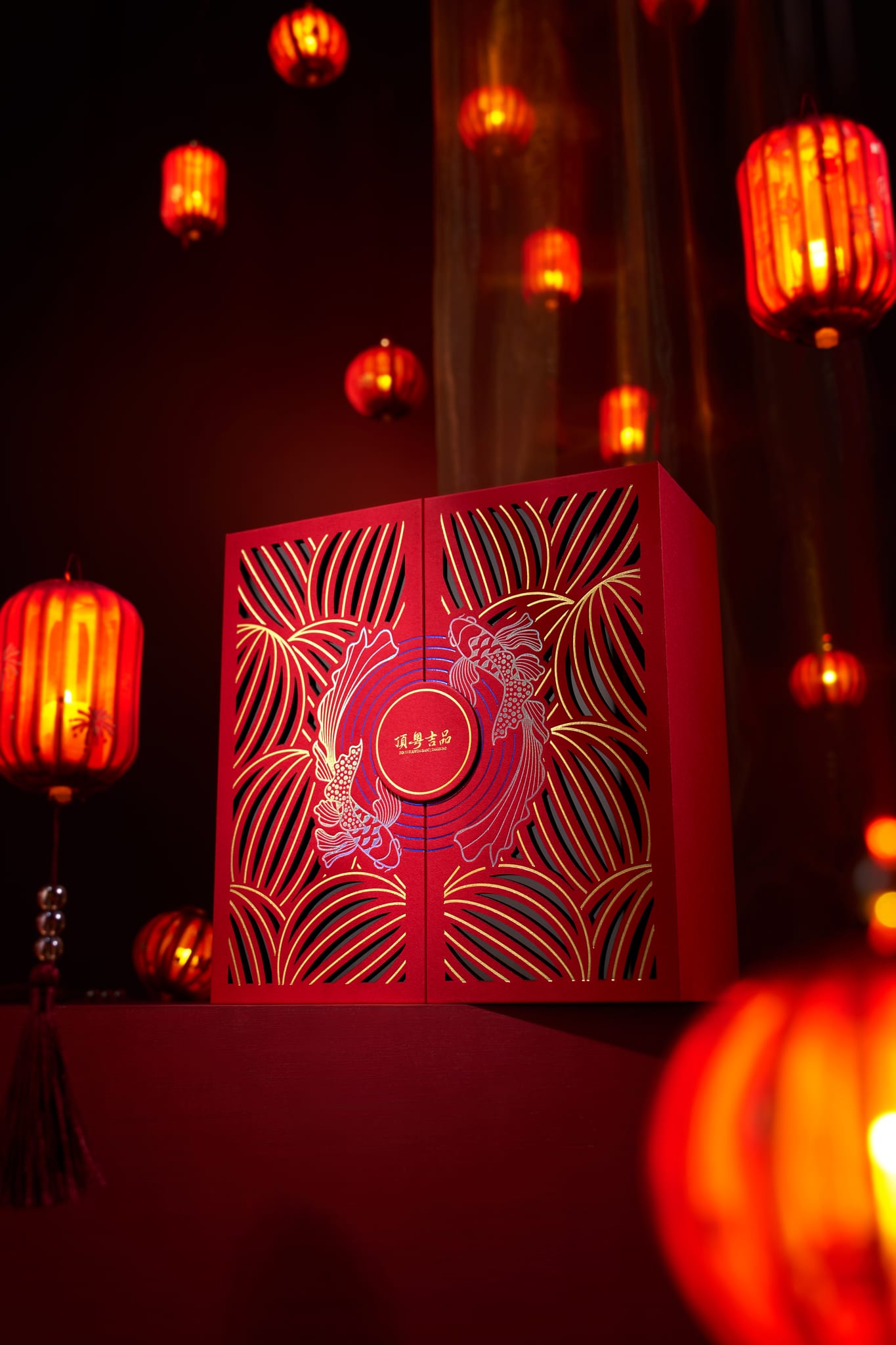一個以燈籠為靈感的紅色禮盒，在溫暖的紅色燈光和懸掛的燈籠中，彰顯其華麗的設計。