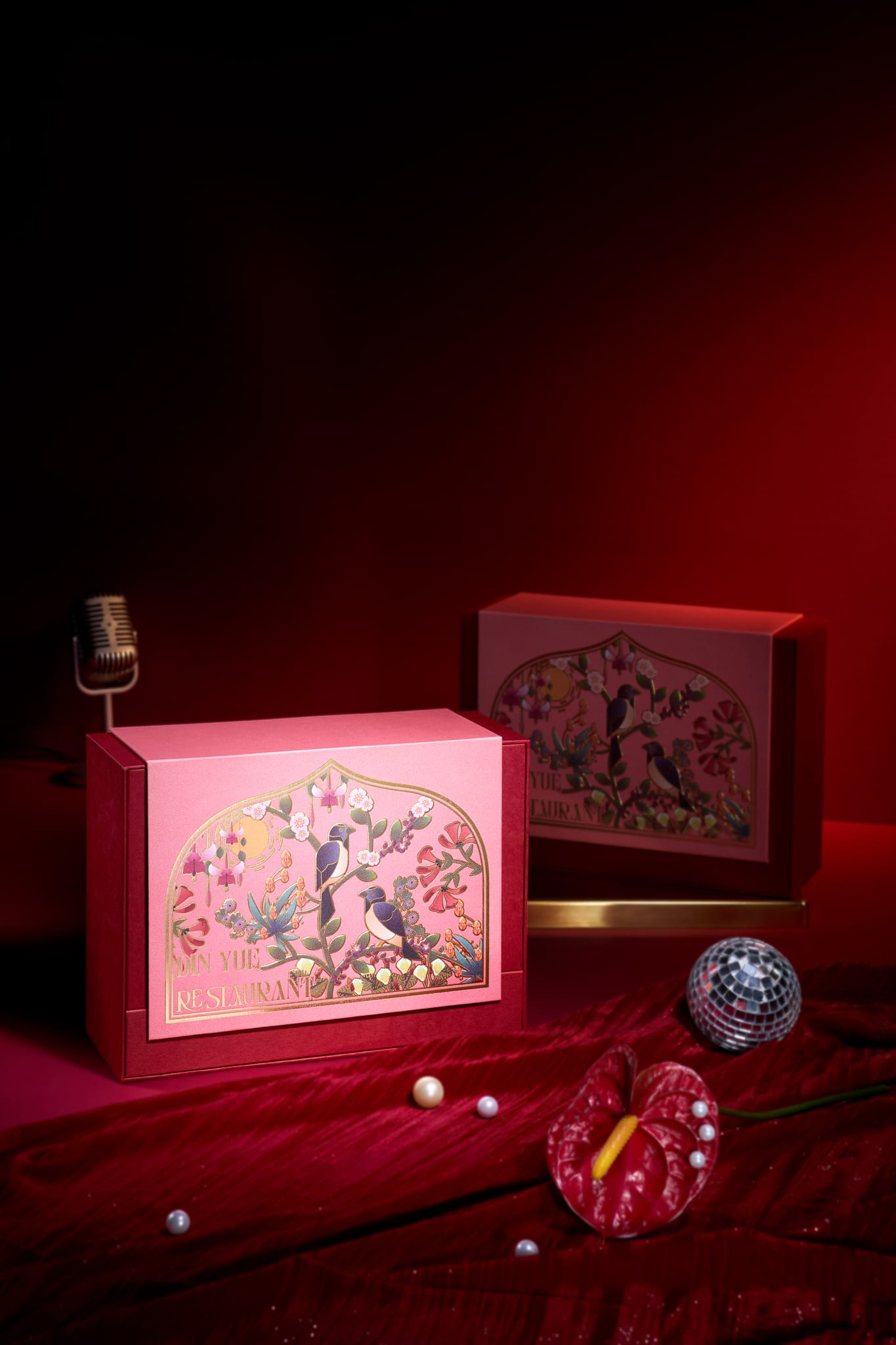 華麗紅絲絨上，禮盒、珍珠與火鶴花營造奢華慵懶氛圍。