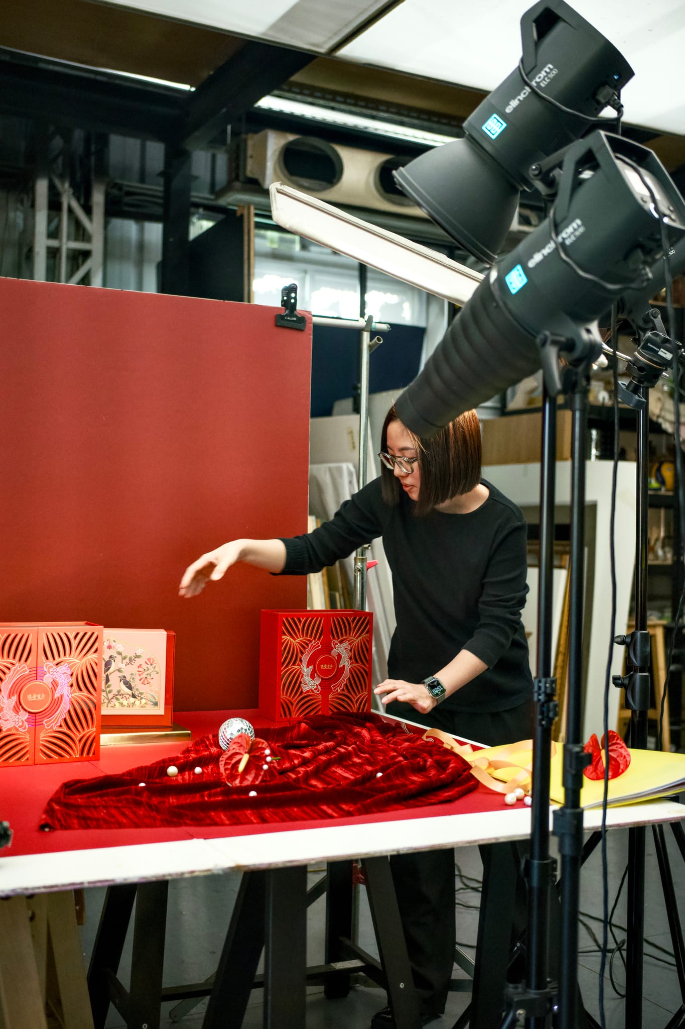 攝影師林巾郁在拍攝現場仔細調整禮盒陳設，呈現華麗精緻的視覺樣貌。