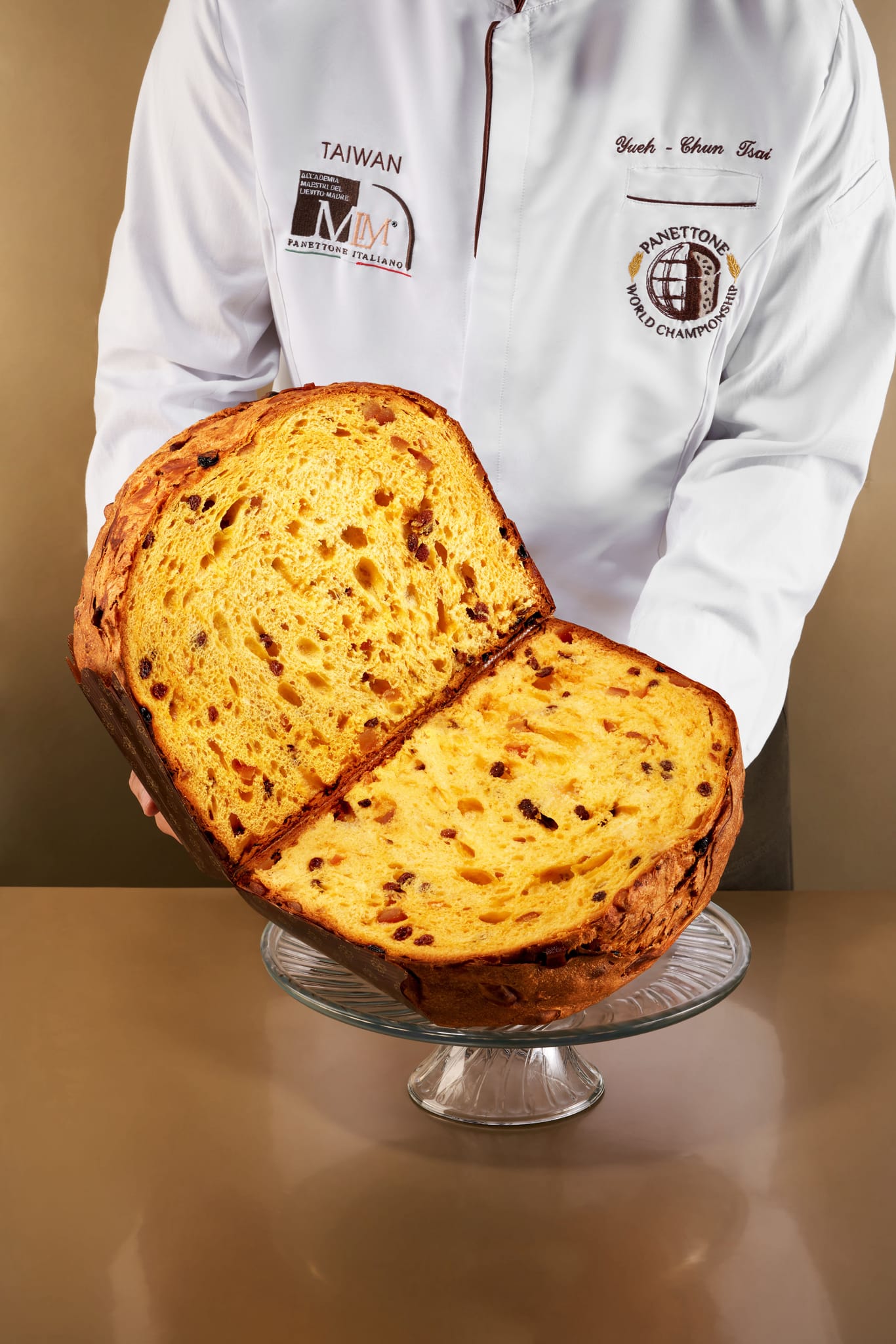 主廚手持巨型切片潘納朵尼，展現冠軍麵包細緻內部。