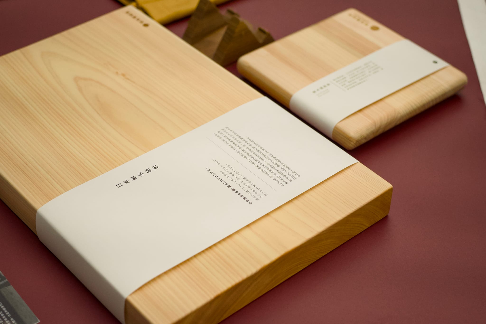 兩個包裝精美的日本檜木砧板，展現木材的天然紋理與溫潤質感，傳遞永續理念。