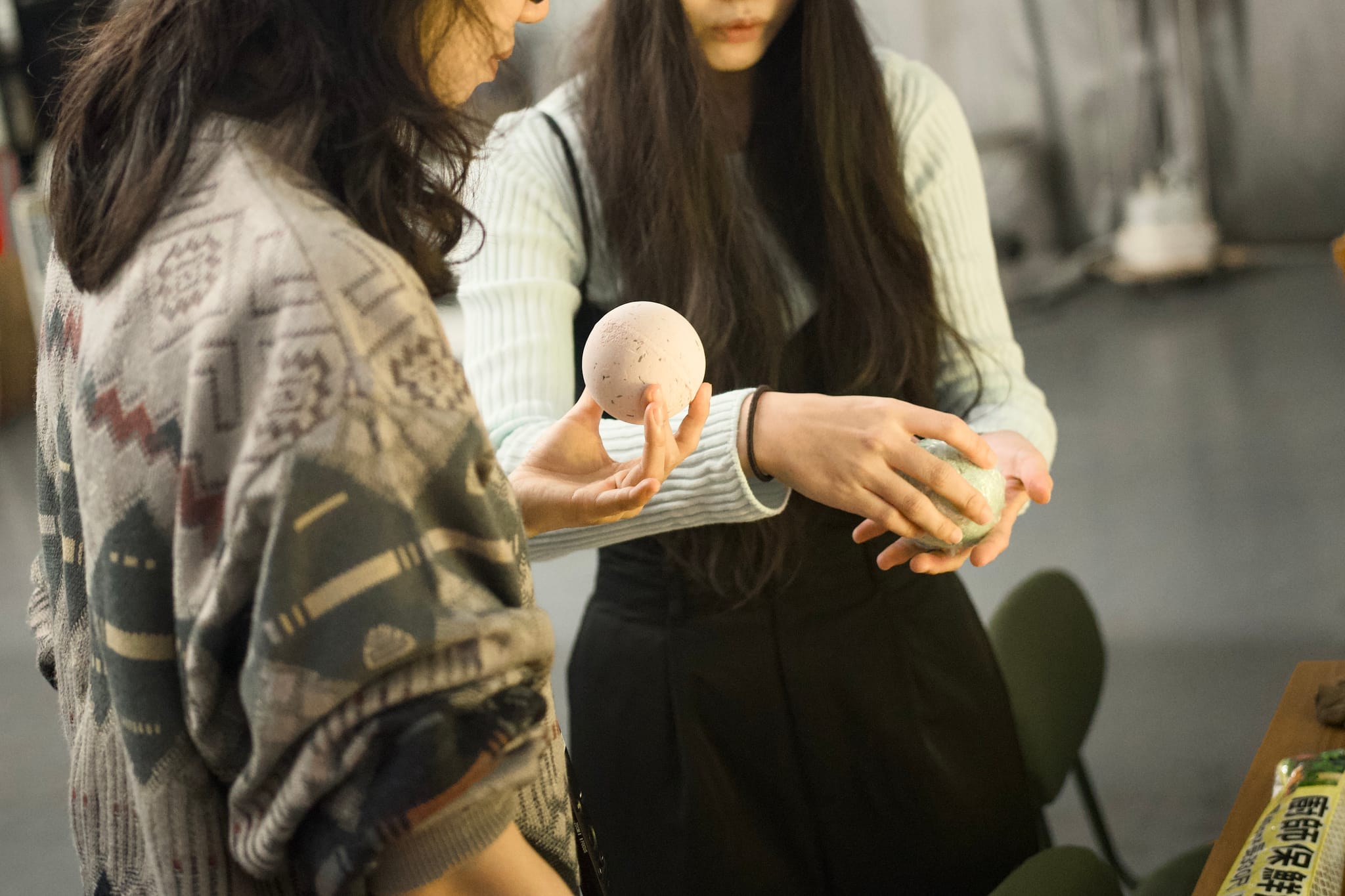 創辦人與攝影師討論手工皂樣貌，手中輕捧圓潤皂體。