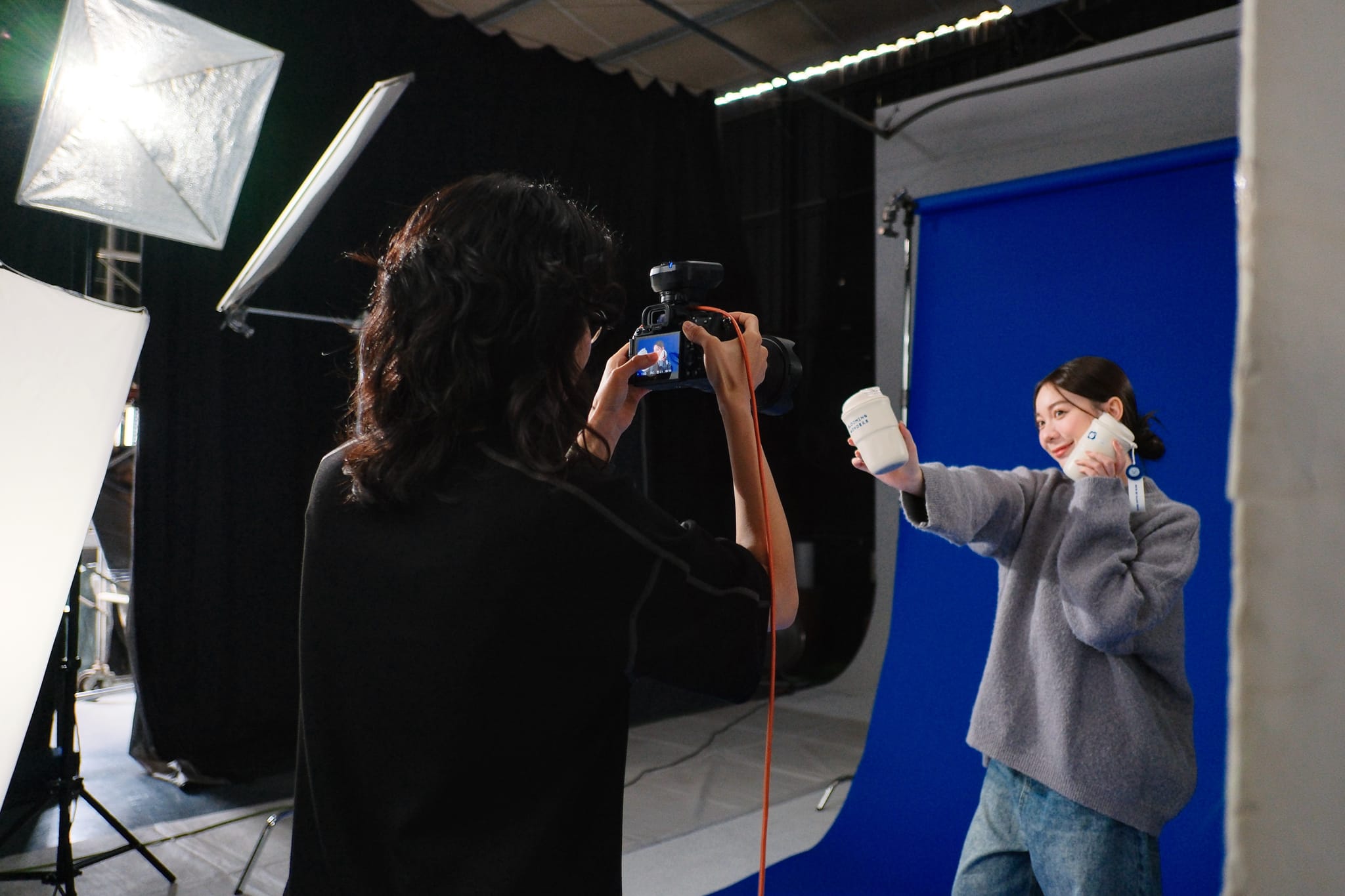 攝影師在棚內引導模特兒，捕捉薇佳XAH!Q聯名商品的治癒系生活感。