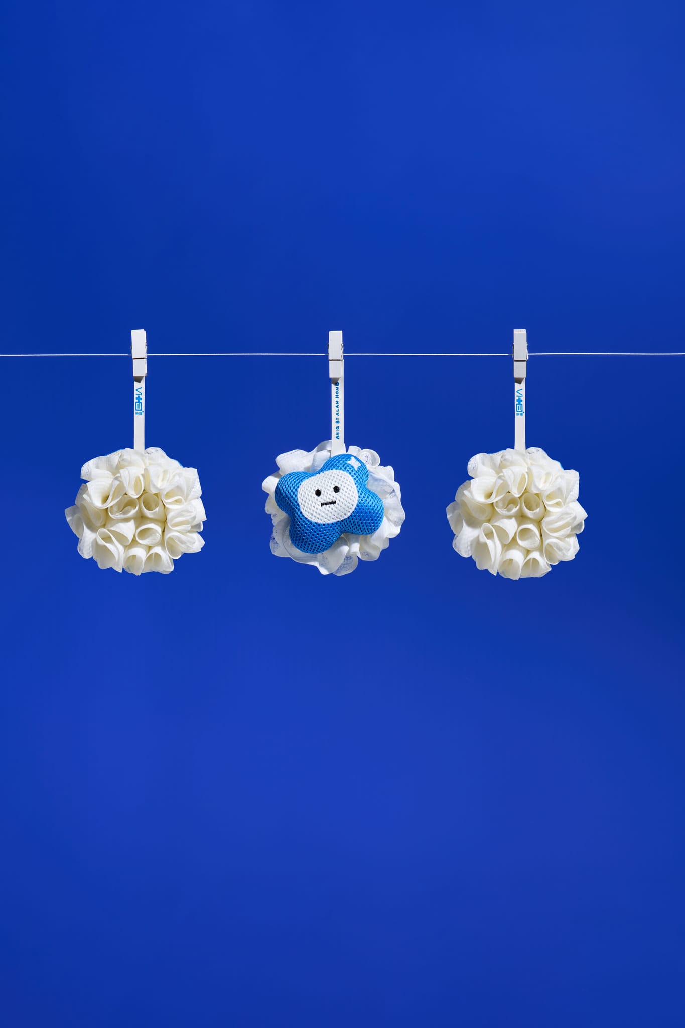 藍白色軟萌雲朵造型洗澡海綿掛於繩上，展現治癒系聯名美學。