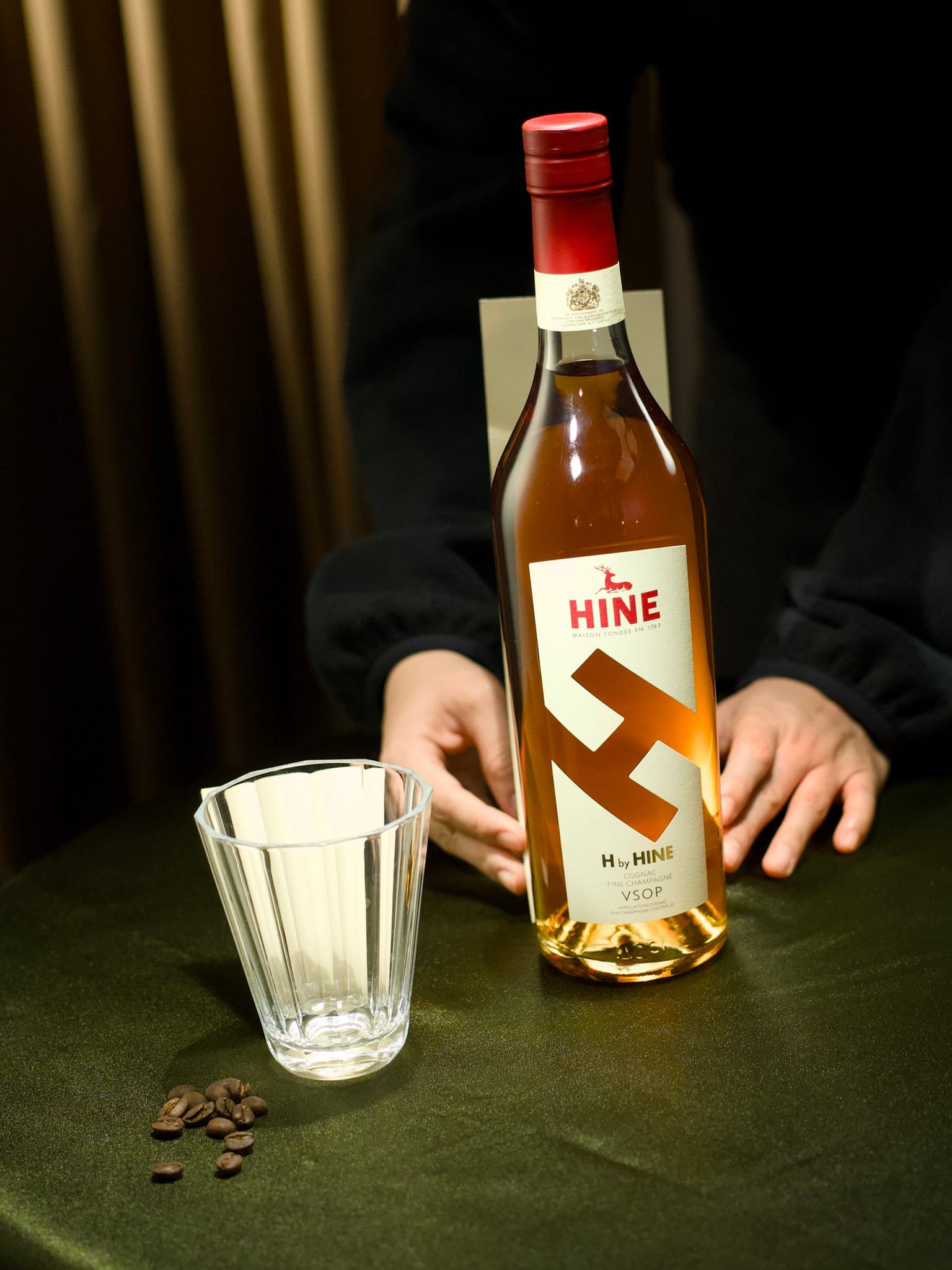 一張專業情境照，捕捉干邑酒瓶的真實質感與人手溫度，建立品牌信任。