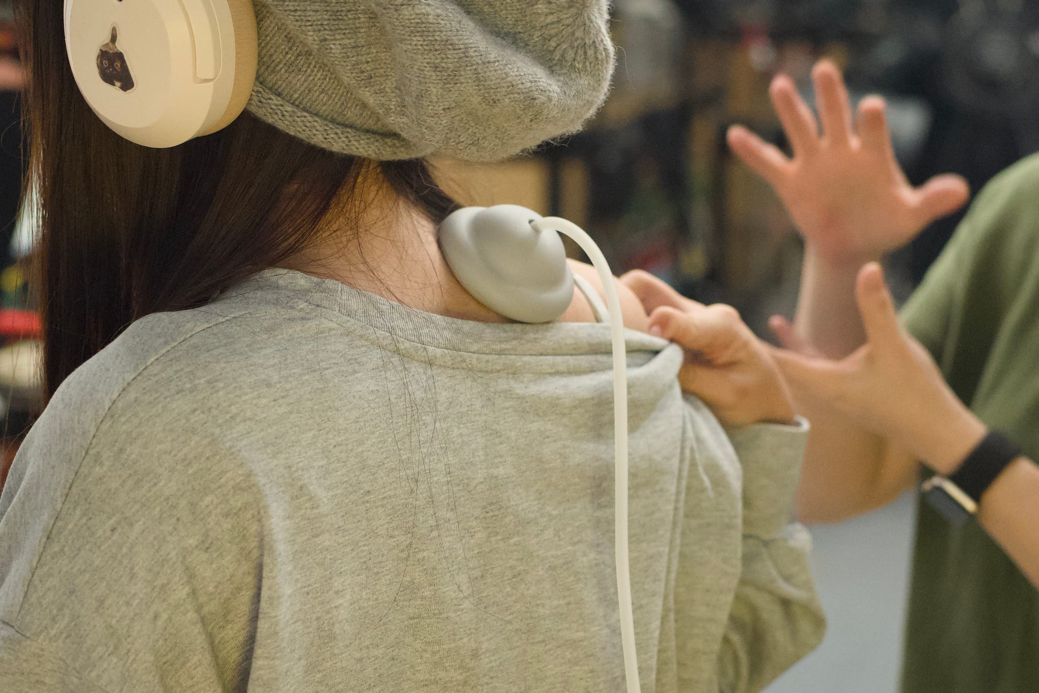 女子使用智能拔罐按摩儀於肩頸，體驗產品放鬆效果。