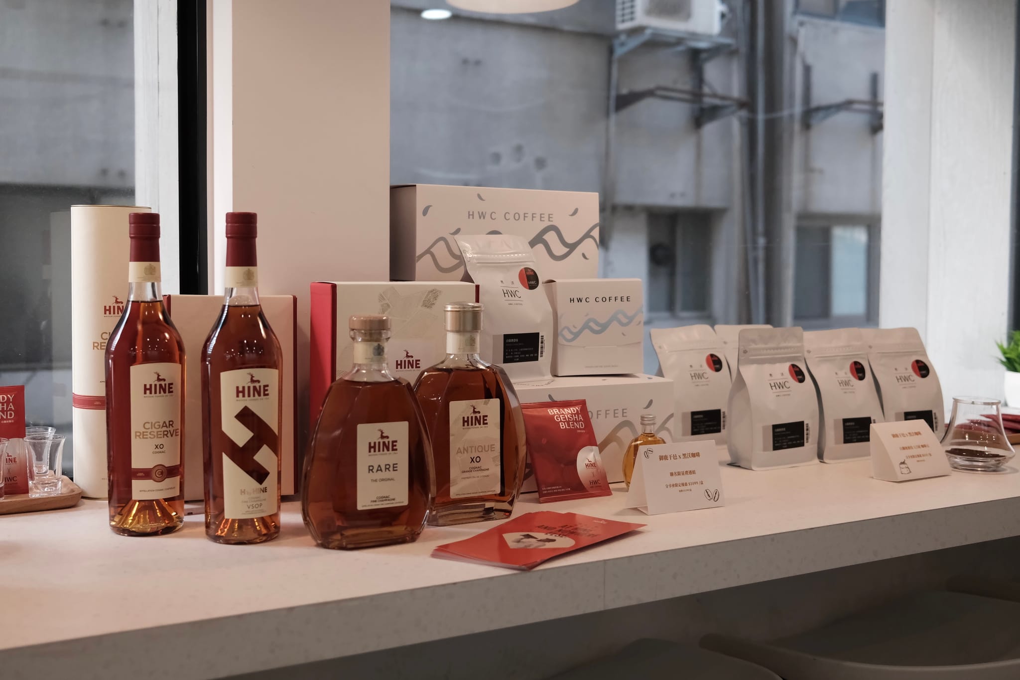 聯名發表會現場，琥珀色干邑酒瓶與黑沃咖啡產品並列展示。