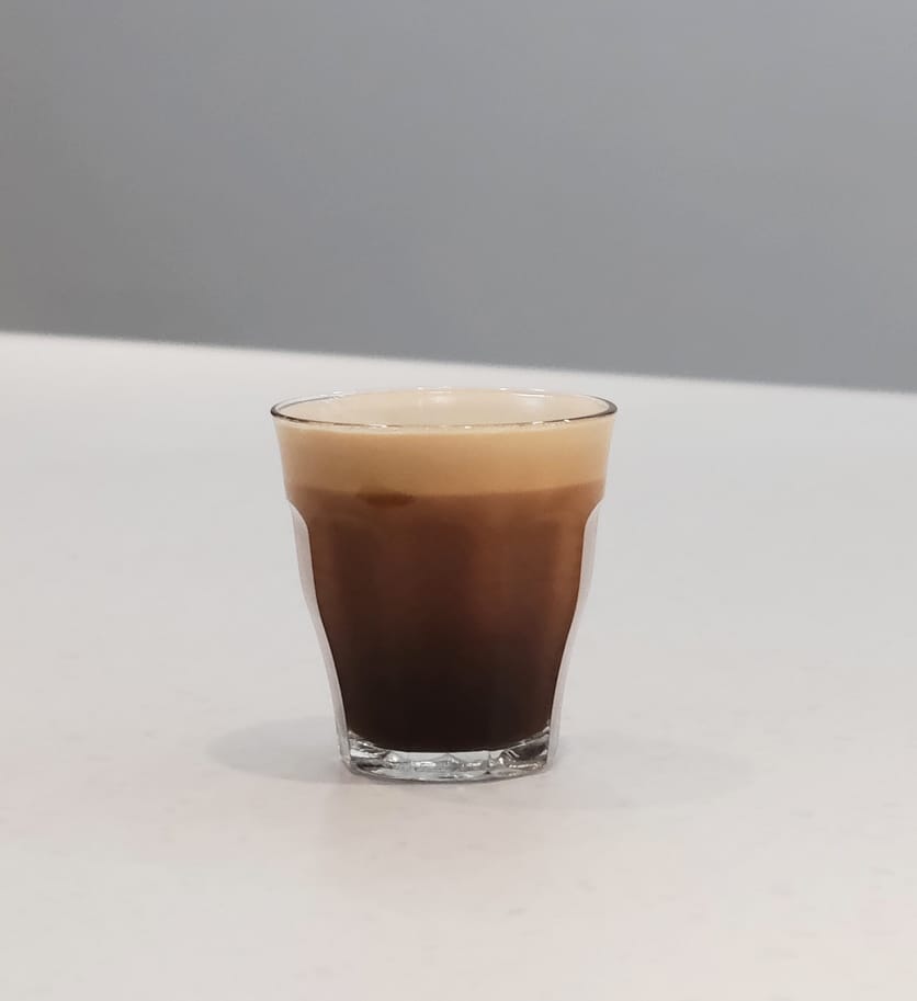 一杯皇家白蘭地美式，深色咖啡體上覆蓋細緻綿密泡沫，誘人可口。