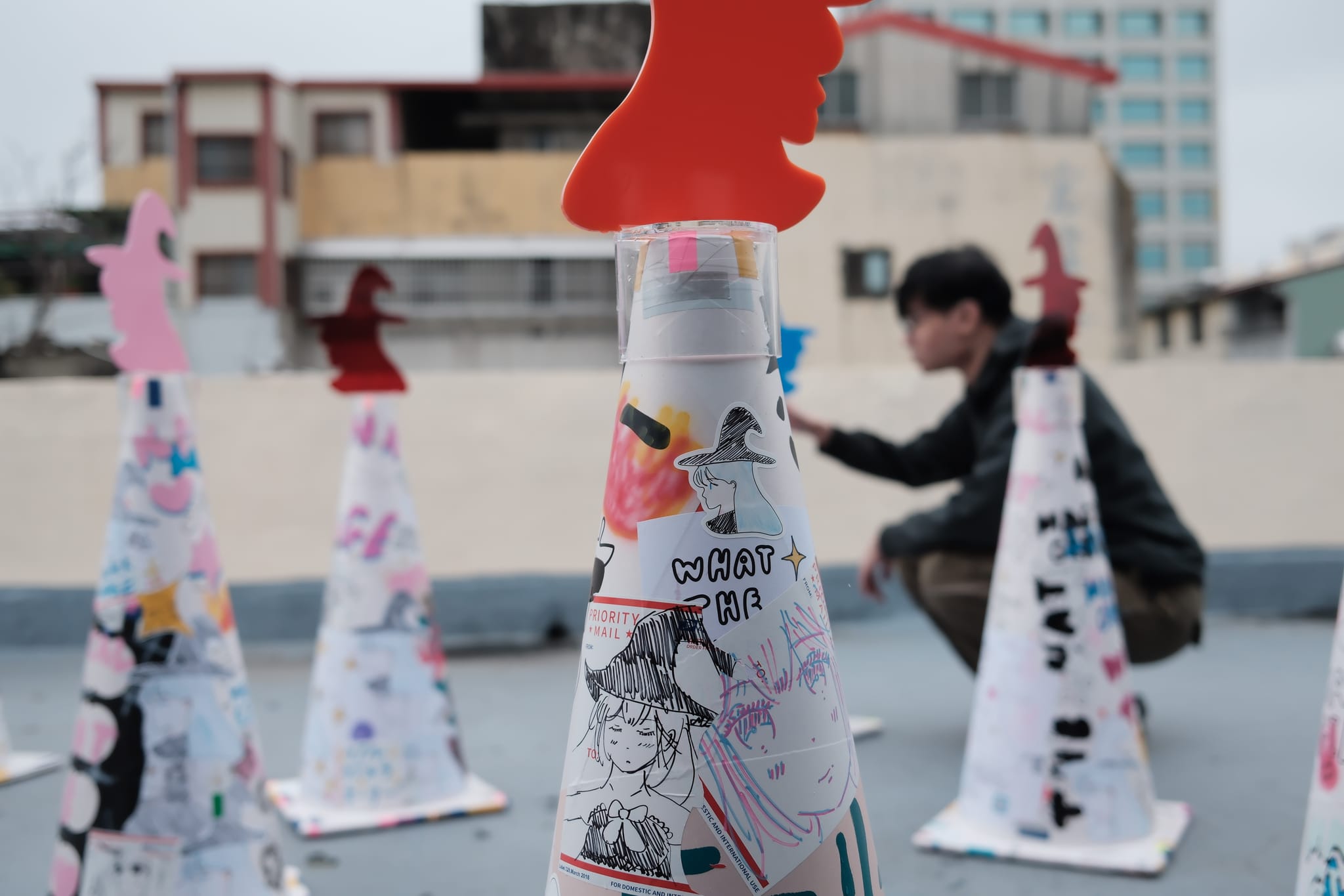 藝術家張鈞傑於展覽現場佈置被魔法少女附魔的交通錐。