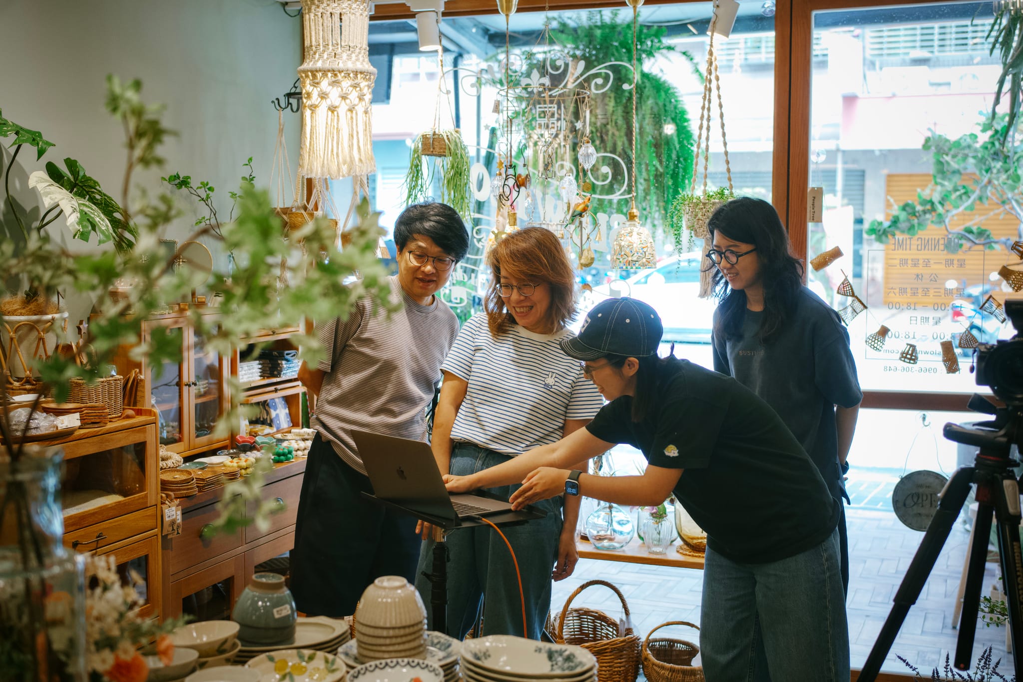 在慢漫全新改裝的店內,幾位工作人員圍著筆記型電腦,仔細檢視商業攝影的成果,背景是店內溫馨的陳列。