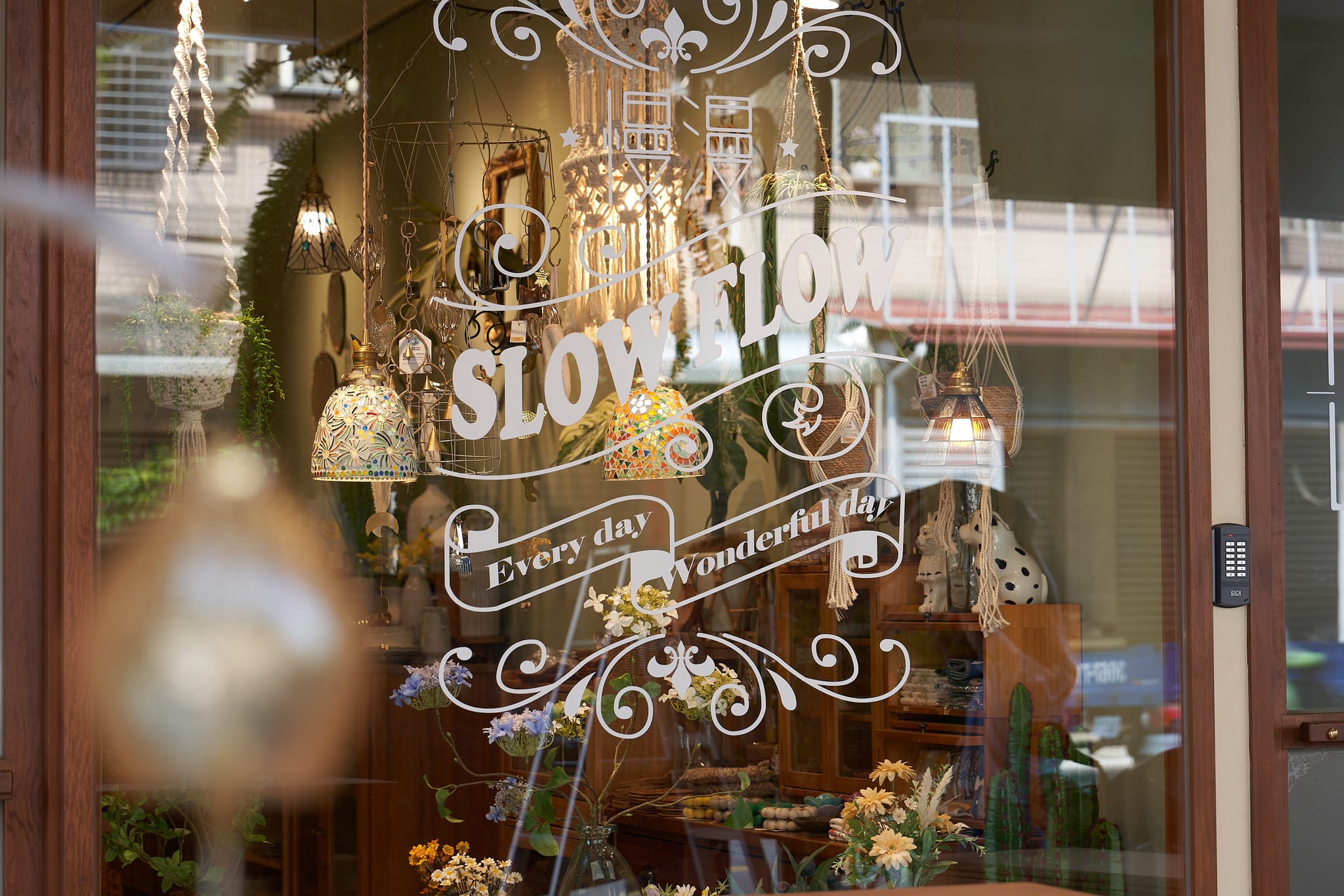 「慢漫 SLOW FLOW」店面玻璃門，品牌名稱與「Every day Wonderful day」字樣印於其上。透過櫥窗，可見店內溫馨佈置，充滿質感選物，引人入內感受慢活哲學。
