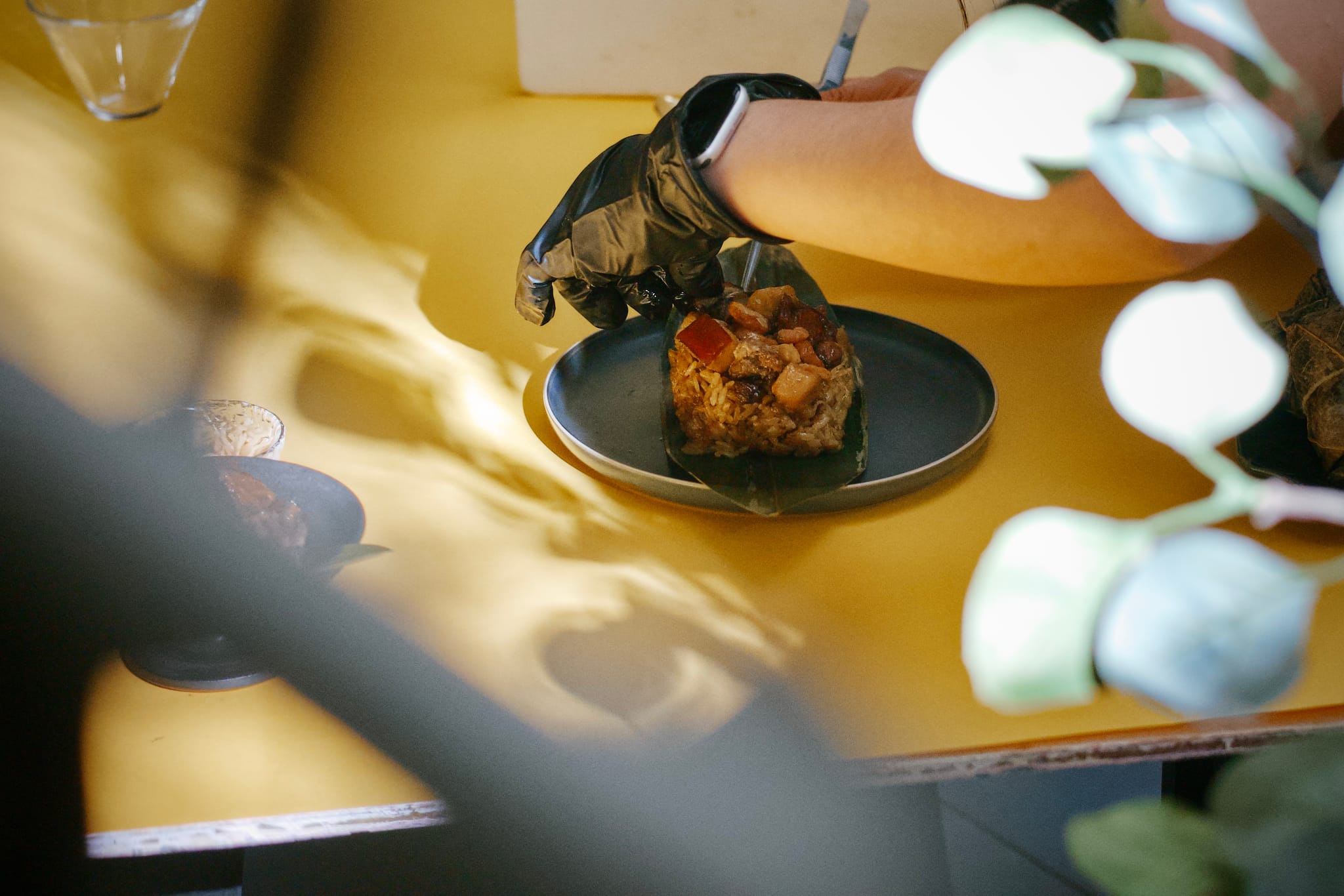 攝影師戴手套細心調整已重組的粽子，展現真實食材。