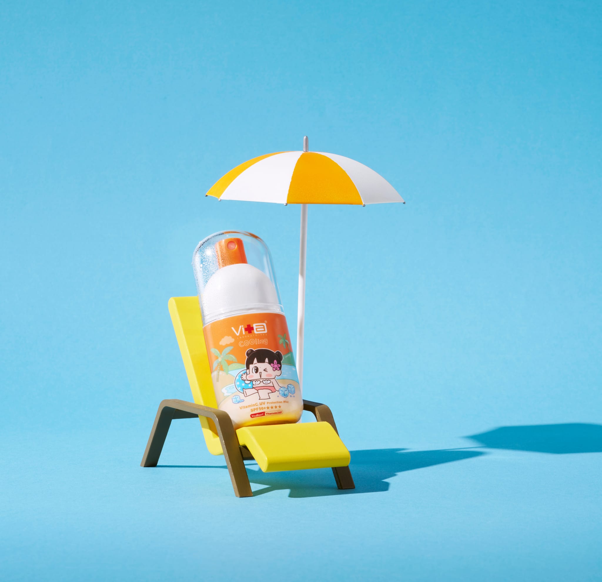 藍色背景中，超C防曬水噴霧(冰爽涼感型)置於3D列印的微縮沙灘椅上，旁有迷你遮陽傘，展現清涼夏日氛圍。