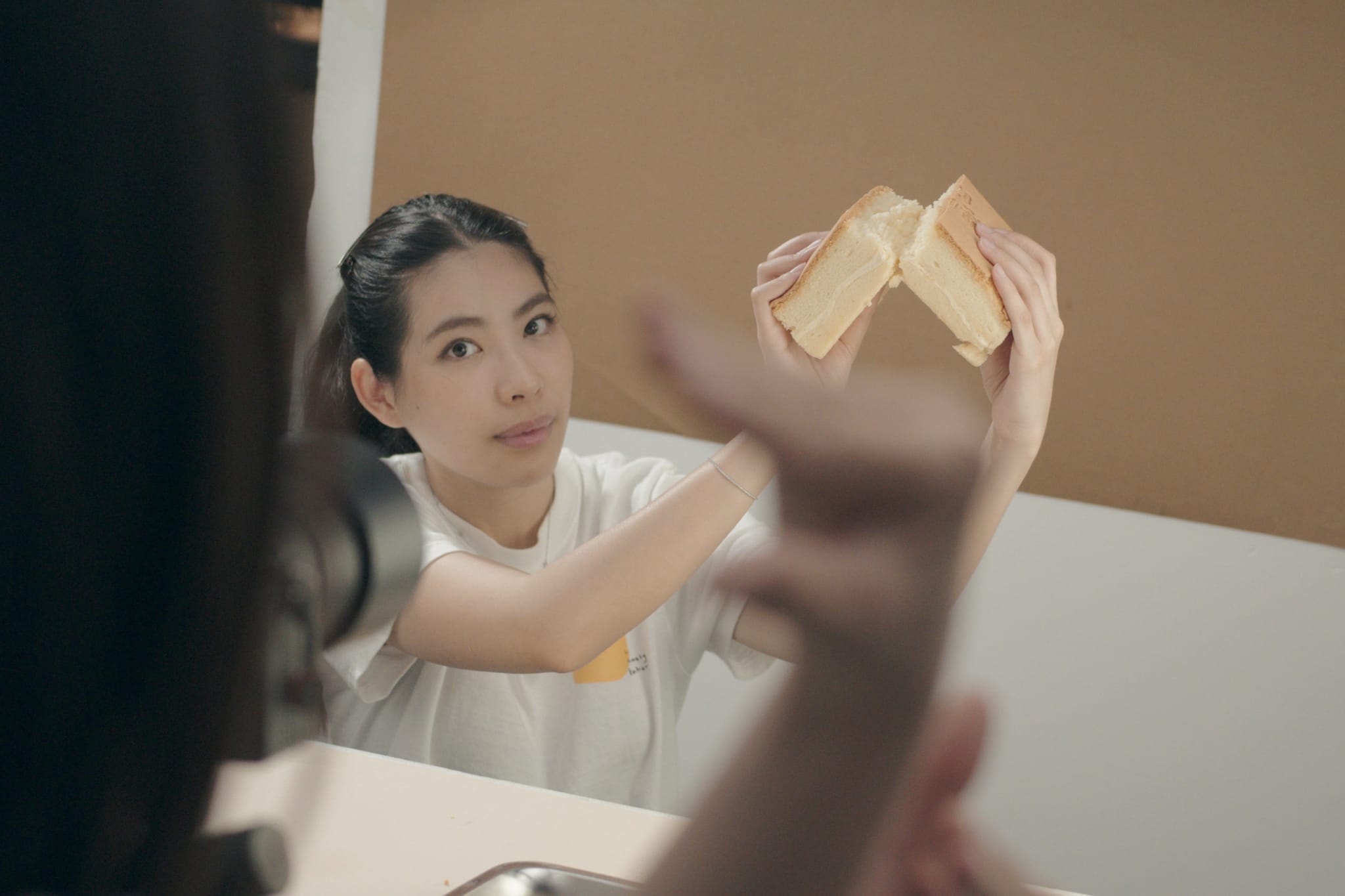 品牌長Alice親自展示剖半的古早味蛋糕，確保其澎鬆質地。