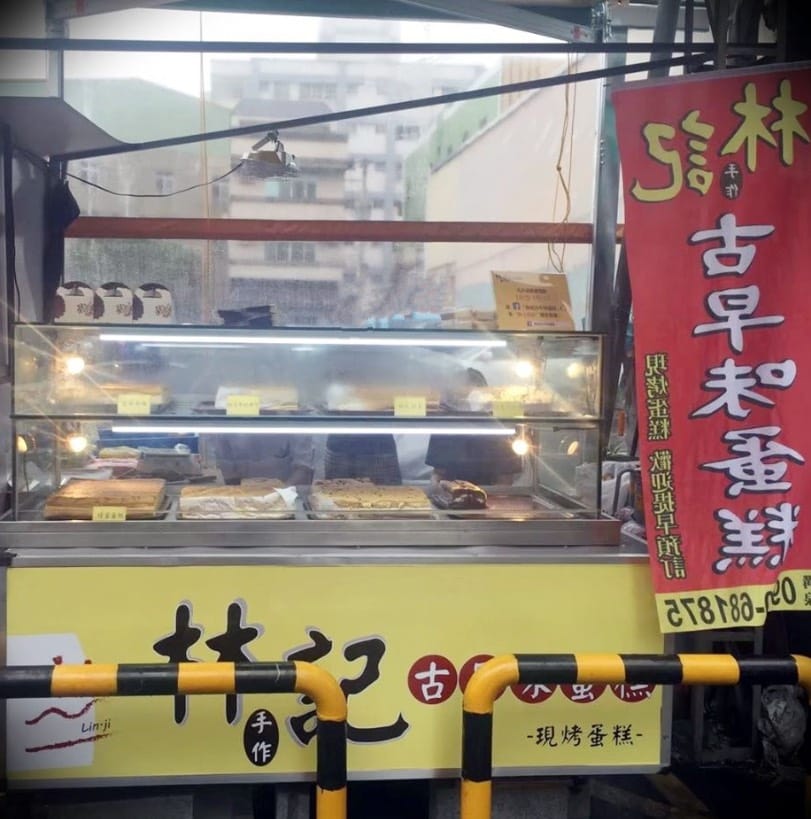 林記糕餅舖創始時的餐車，販售著玻璃櫃中熱騰騰的古早味蛋糕，攤車上掛著寫有「林記古早味蛋糕」的紅色布旗。