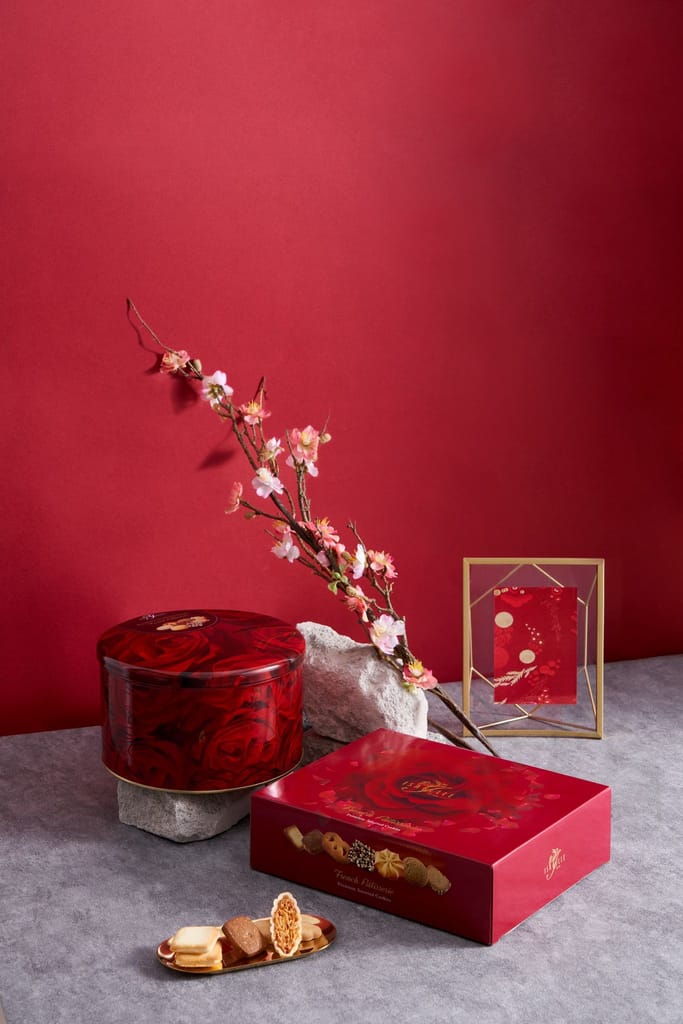 紅色節慶禮盒與綻放粉色花朵，烘托溫馨氛圍，展現品牌心意。